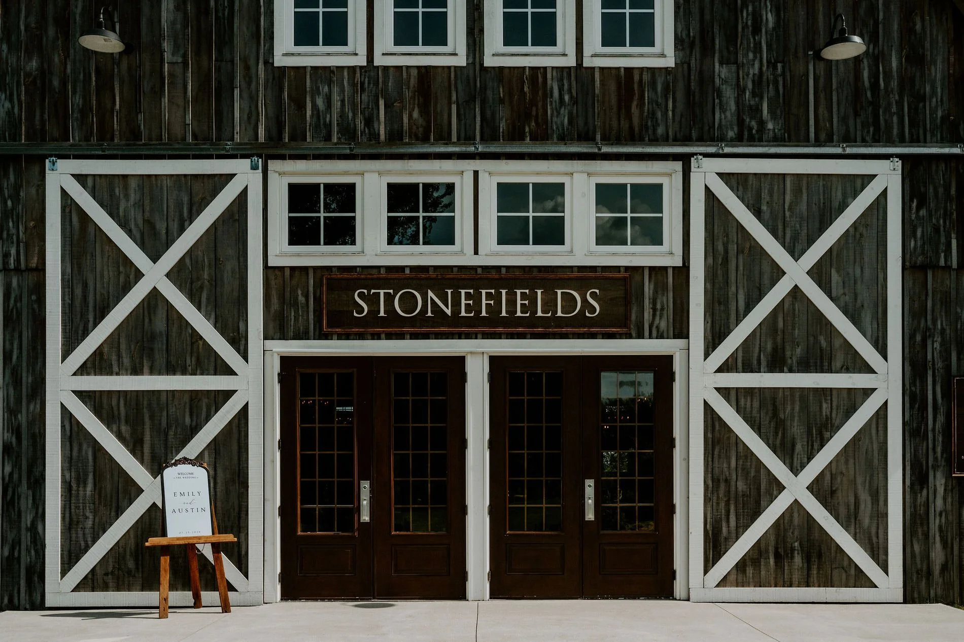 The Stonefields barn doors with an "Emily &amp; Austin" welcome sign on an easel