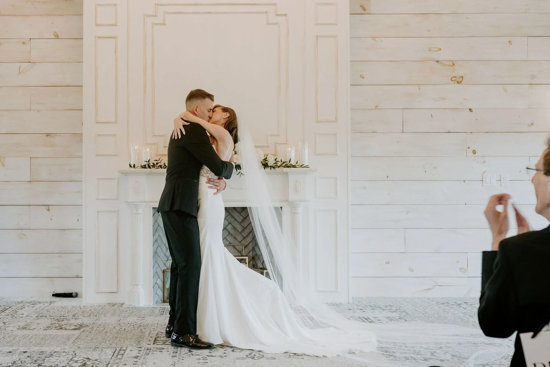 Emily and Austin's first kiss in front of the white fireplace in the chapel at Stonefields Estate