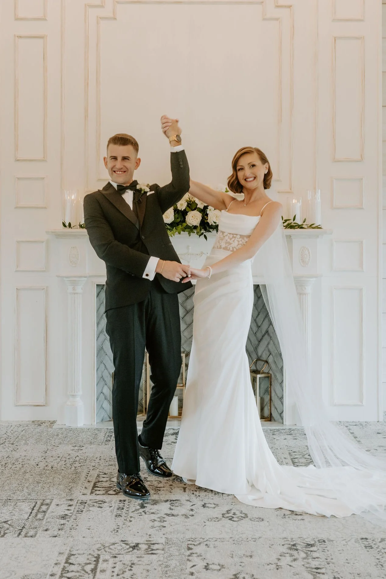 Emily and Austin raising their joined hands in celebration after the ceremony