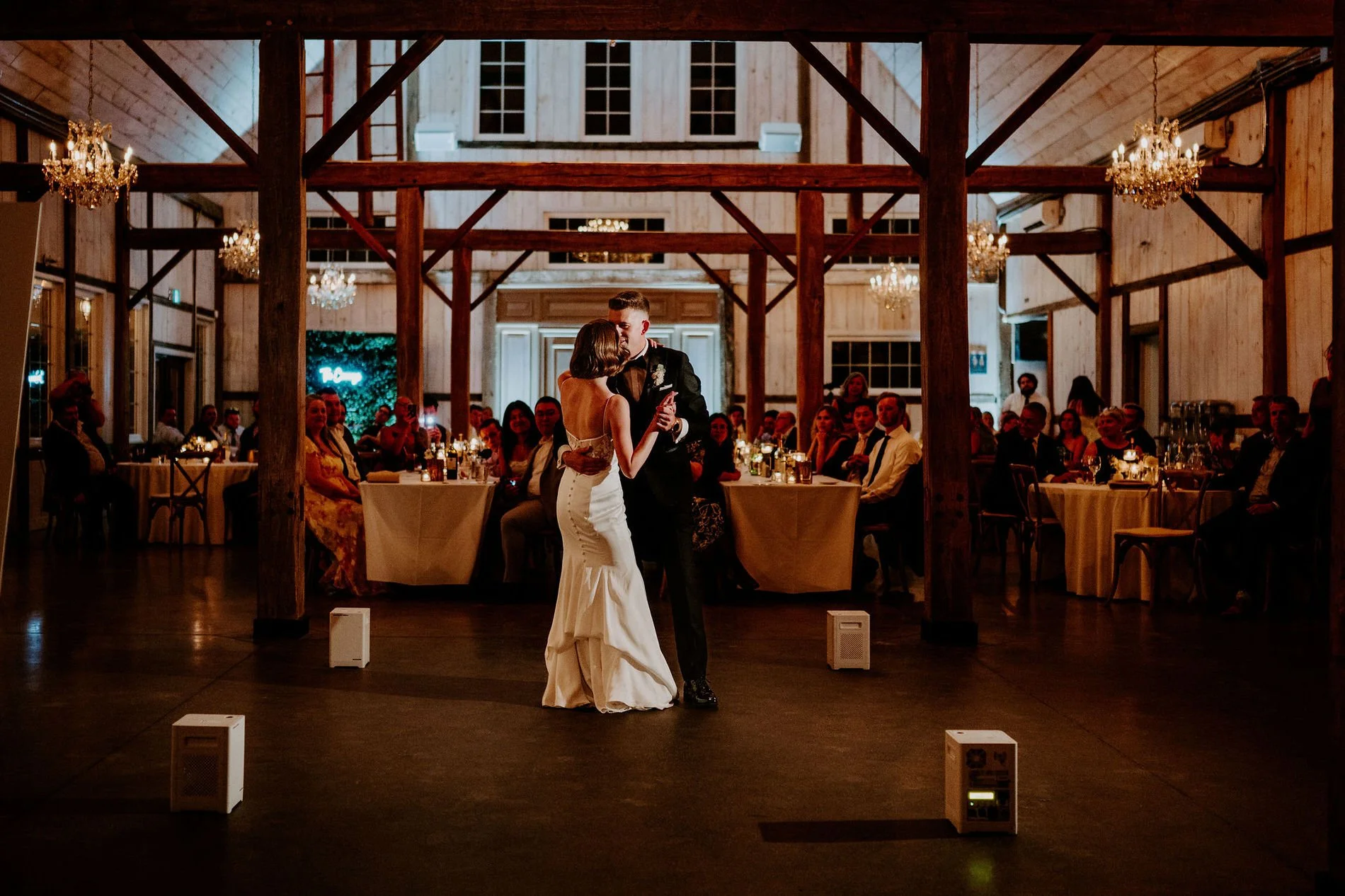 Emily and Austin's first dance under the chandeliers and timber beams of the Stonefields barn
