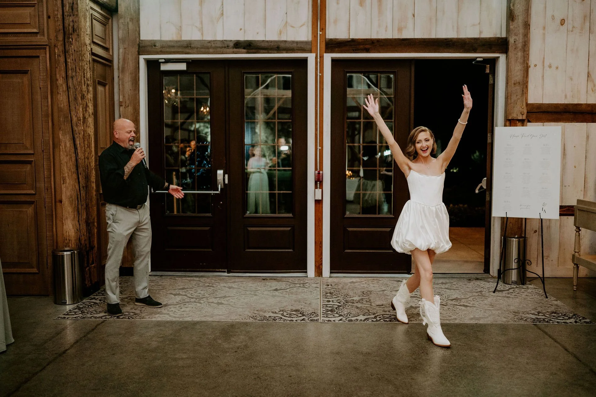 Emily making a second entrance in a short white dress and white cowboy boots