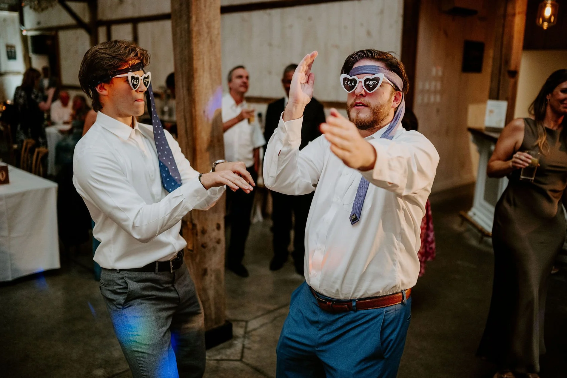Two guests dancing in heart-shaped "E&amp;A" sunglasses