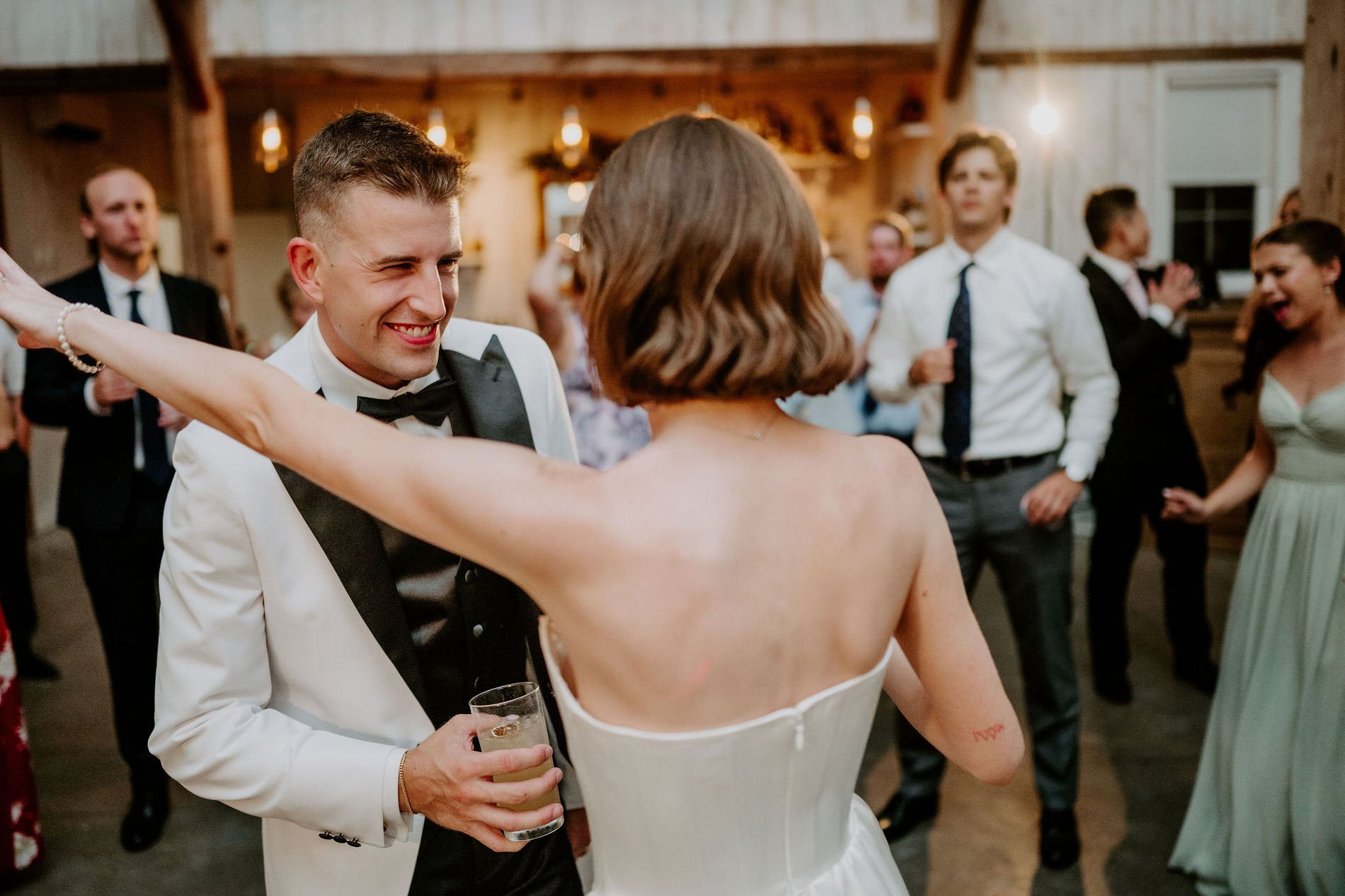 Austin grinning as Emily dances with him on the dance floor