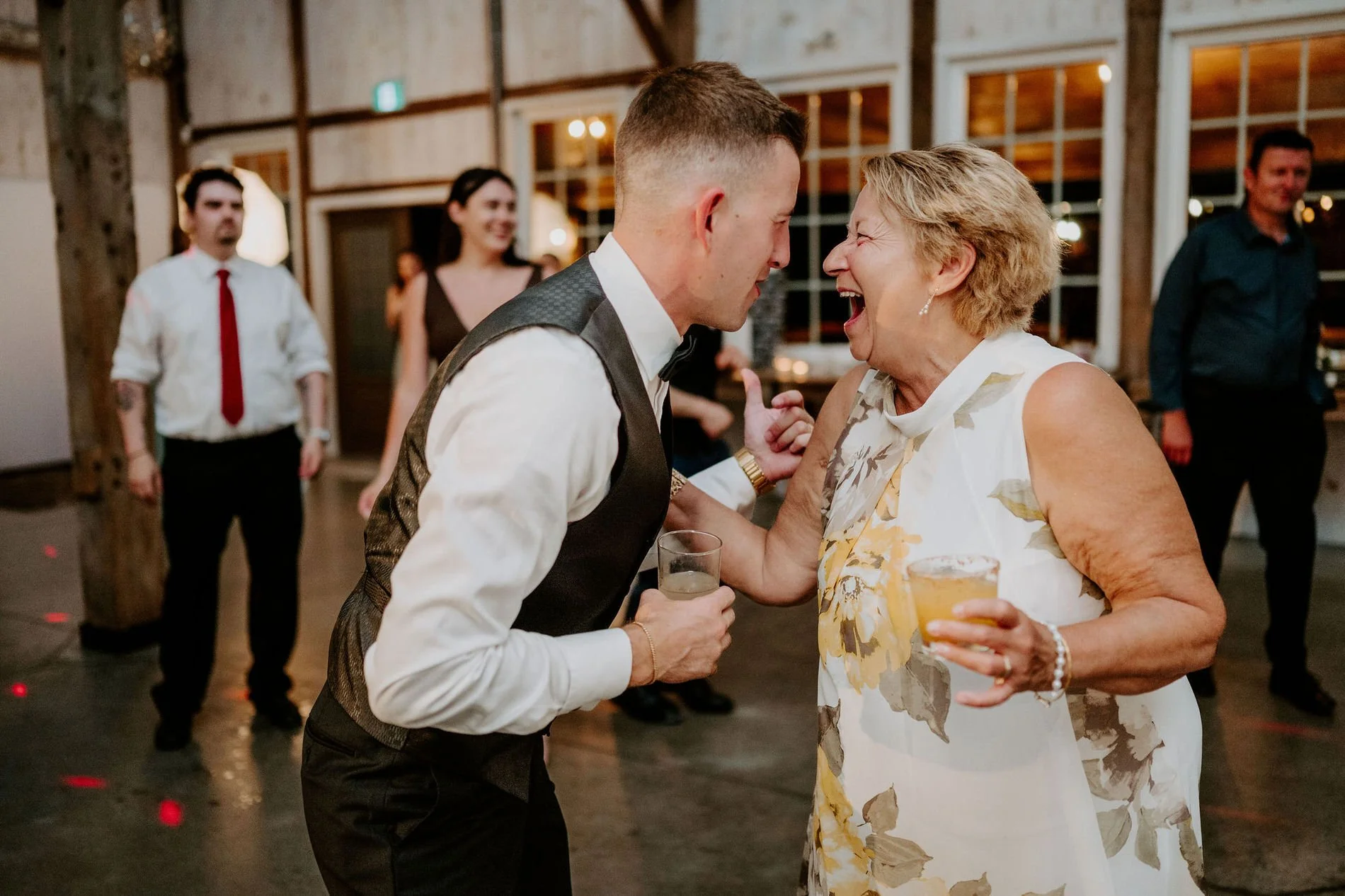 Austin sharing a big laugh with an older woman on the dance floor at Stonefields Estate