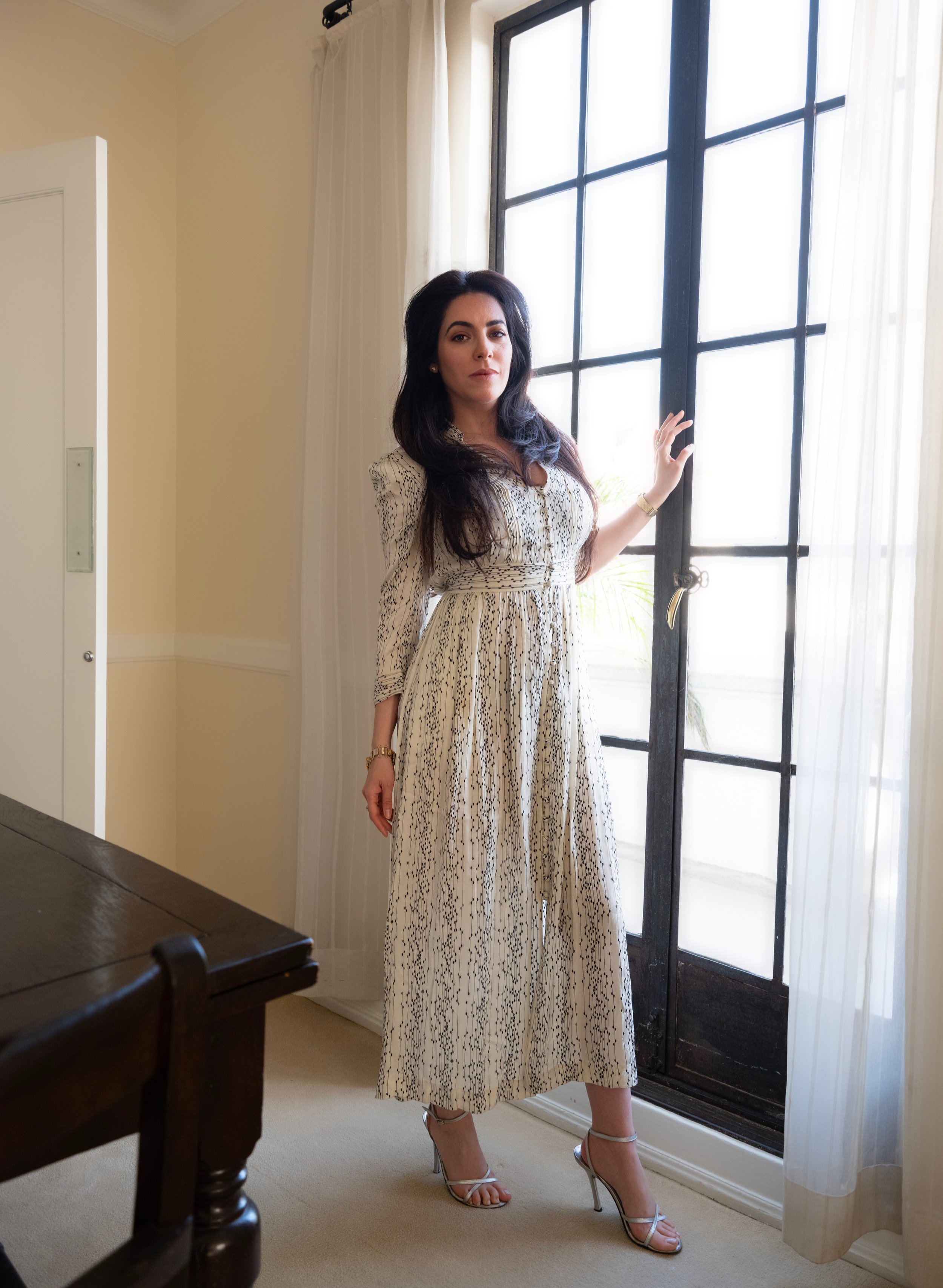  Maje Casben in a white dress, captured in soft natural light by the dining room window – editorial actor and model portfolio image shot in a Hollywood penthouse setting. 