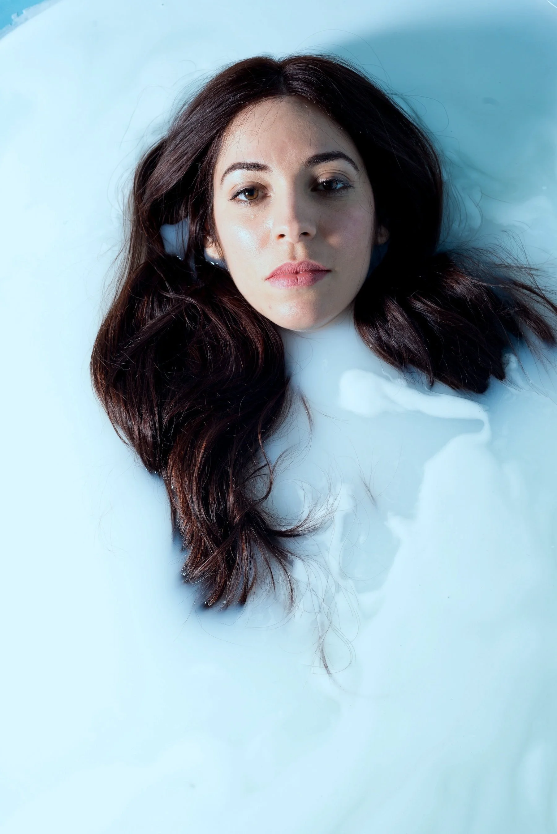 Maje Casben in a white milk bath – serene portrait of Latina actress and model