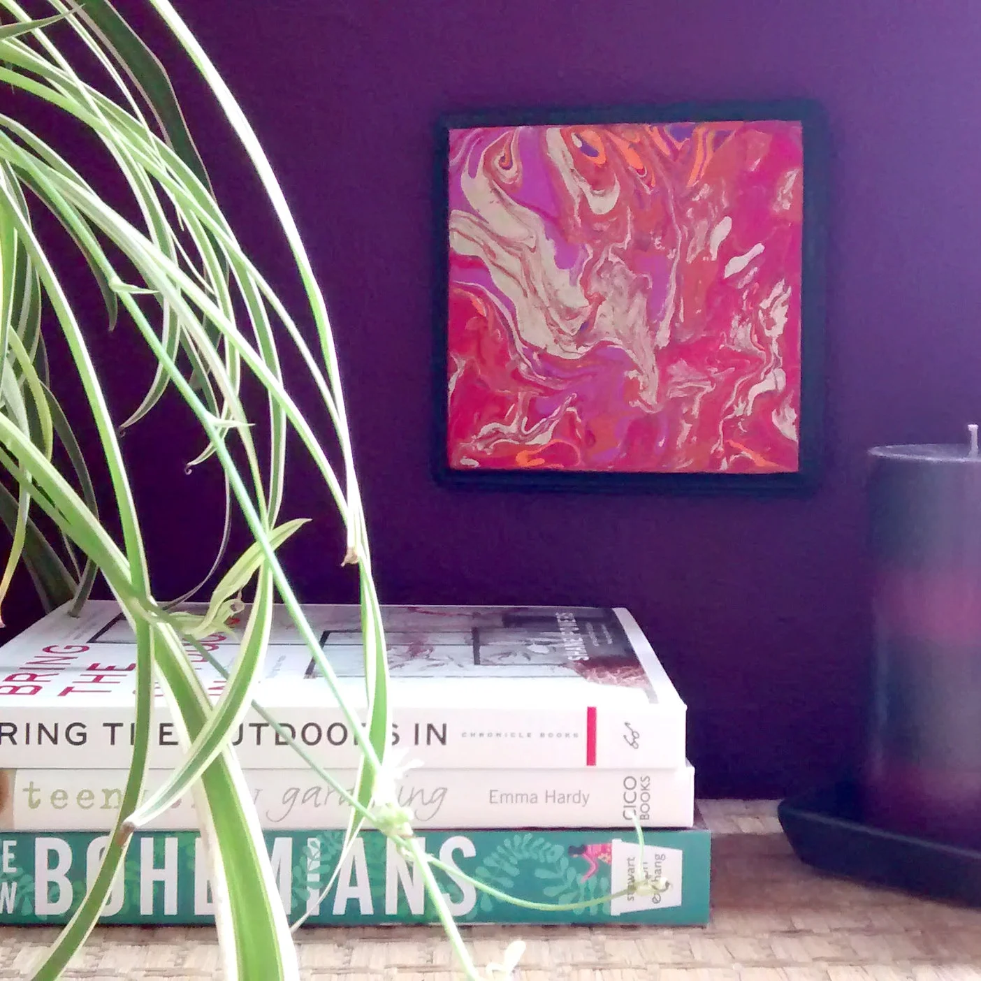 Marbled art Fire Dance hand painted by Stacey Taylor of Effortlessly Eclectic displayed on wicker trunk at purple wall with books candles and spider plant
