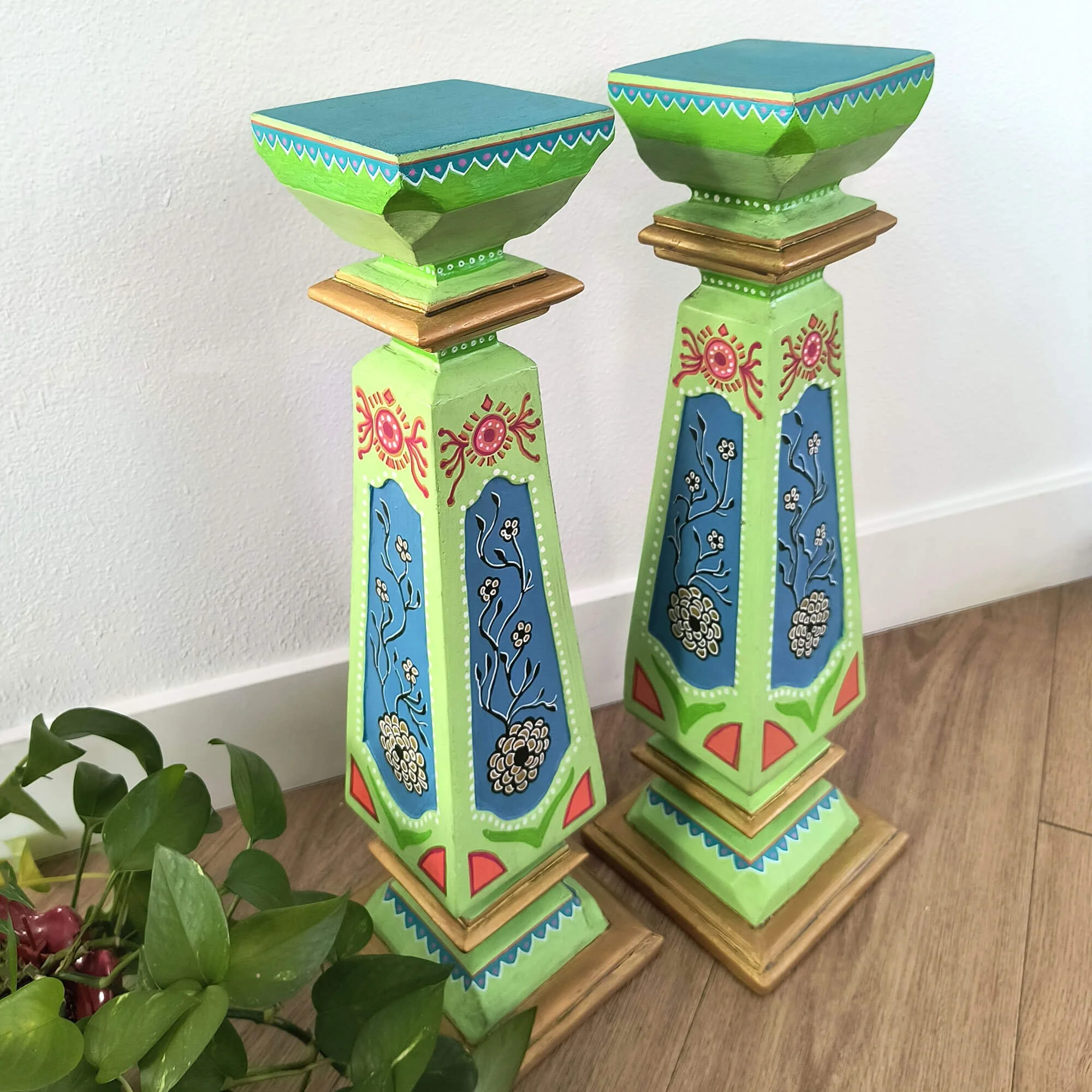 Folk art furniture style colorfully hand-painted decorative pedestals set with details of flowers and suns. Second view showing tops.