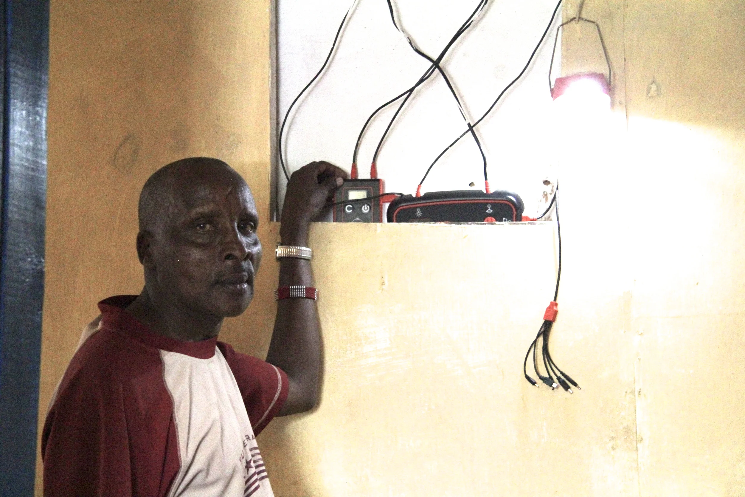 Maasai farmer Daniel Tempes Olinapa switching on his bedroom light