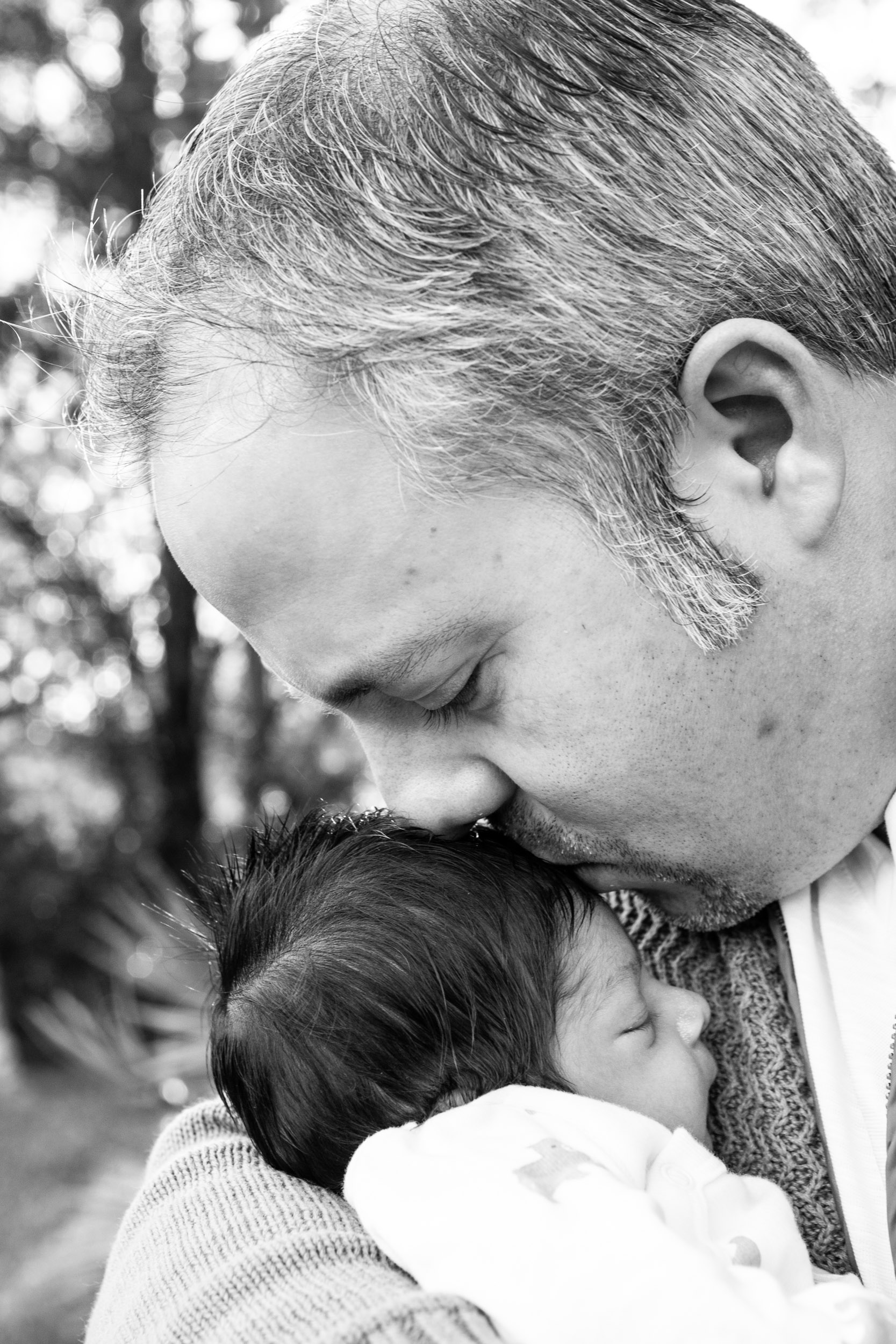 dad kissing newborn baby boy