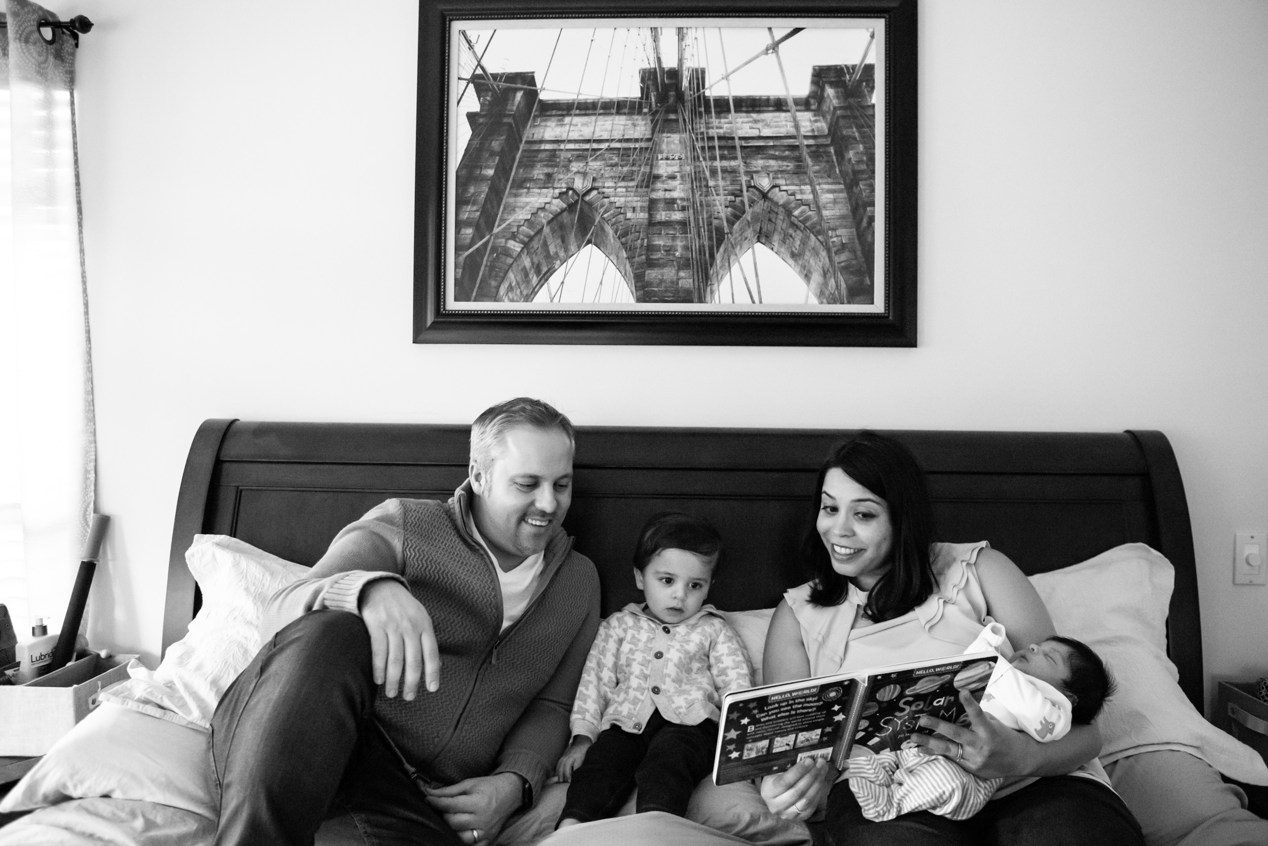 family with two small children reading a book