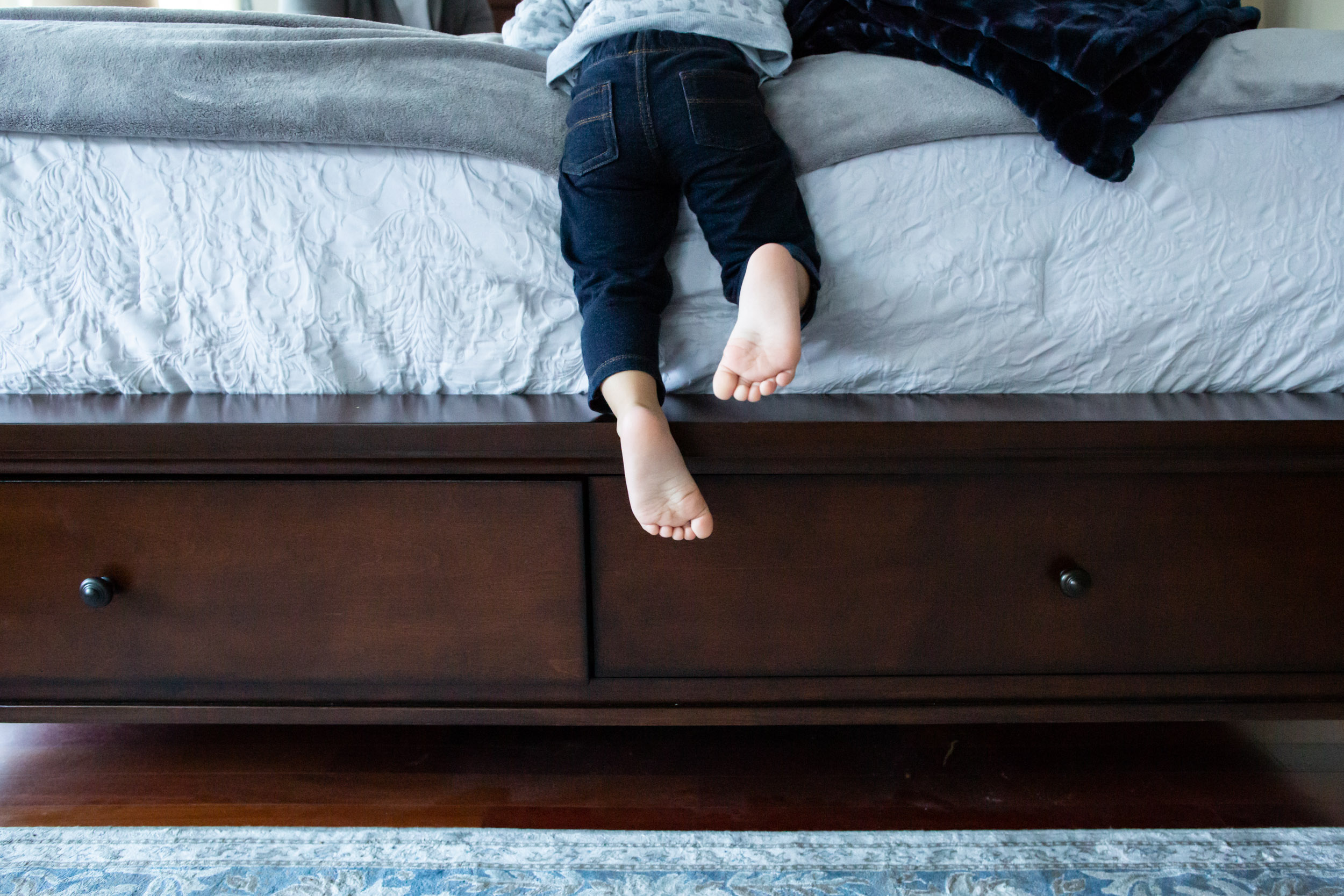 little boy's feet on edge of bed