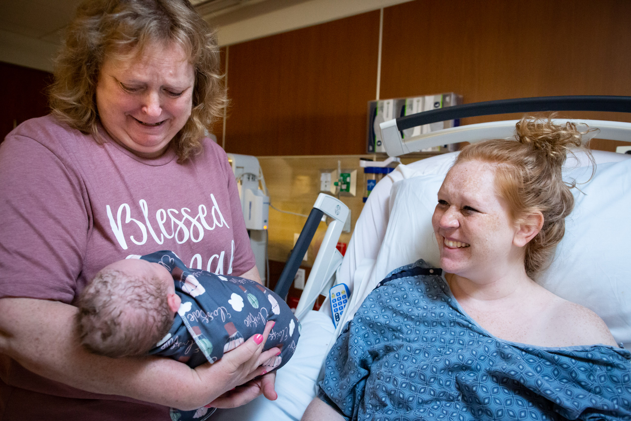 three generations admiring newborn baby girl