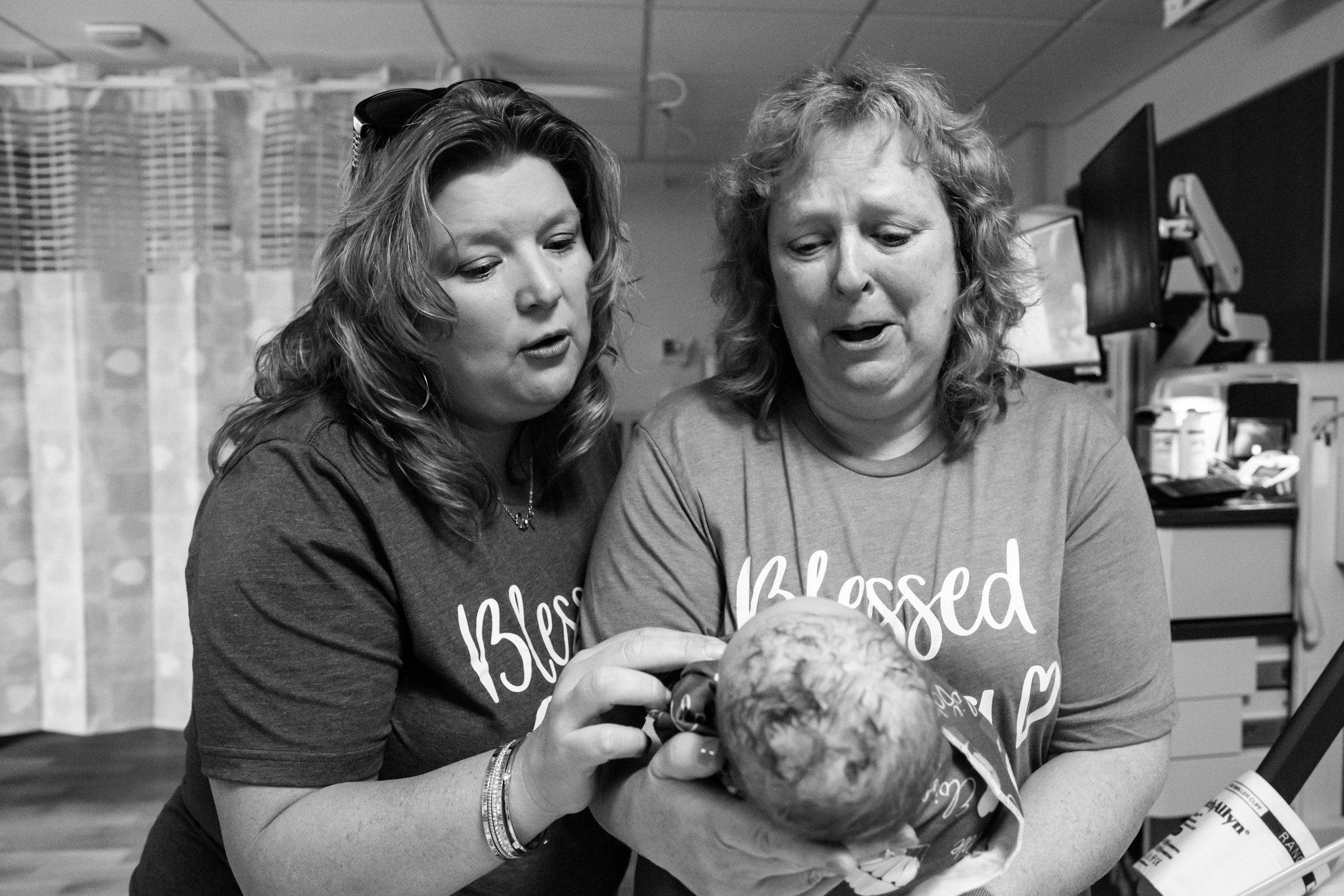 grandmothers looking at newborn baby girl