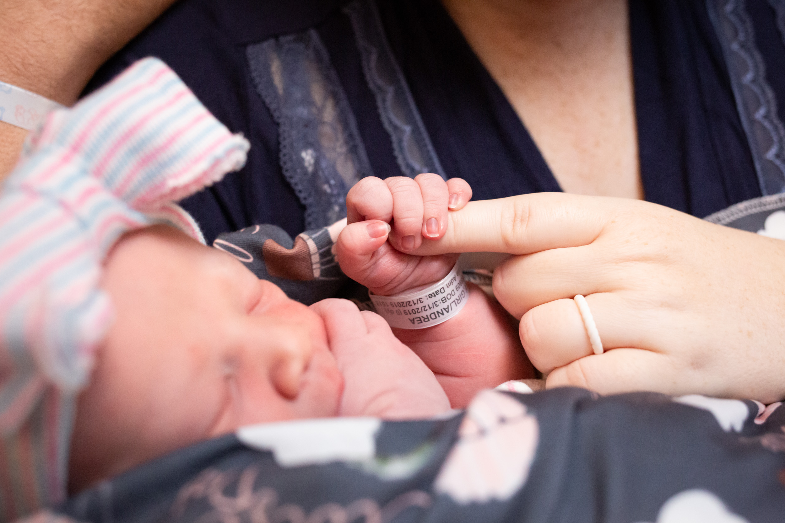 baby holding mom's finger
