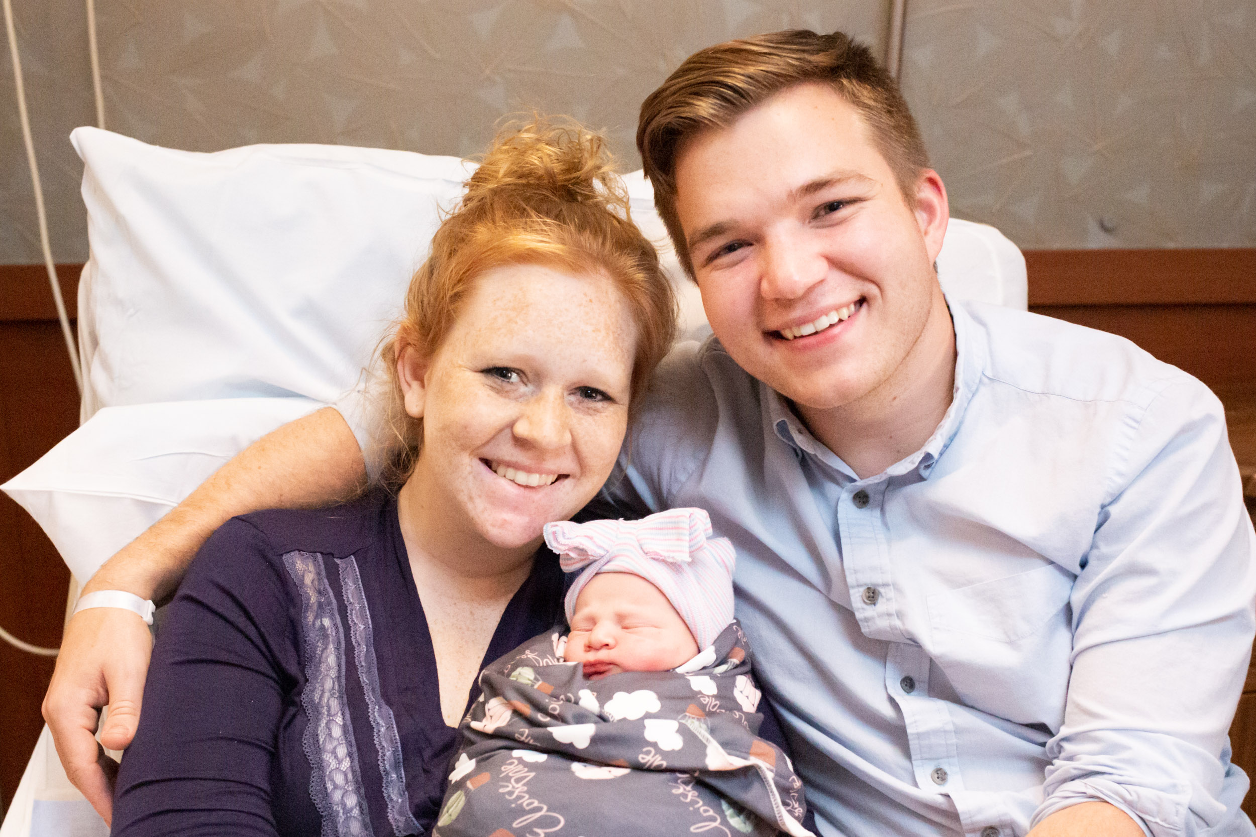 new parents smiling with newborn