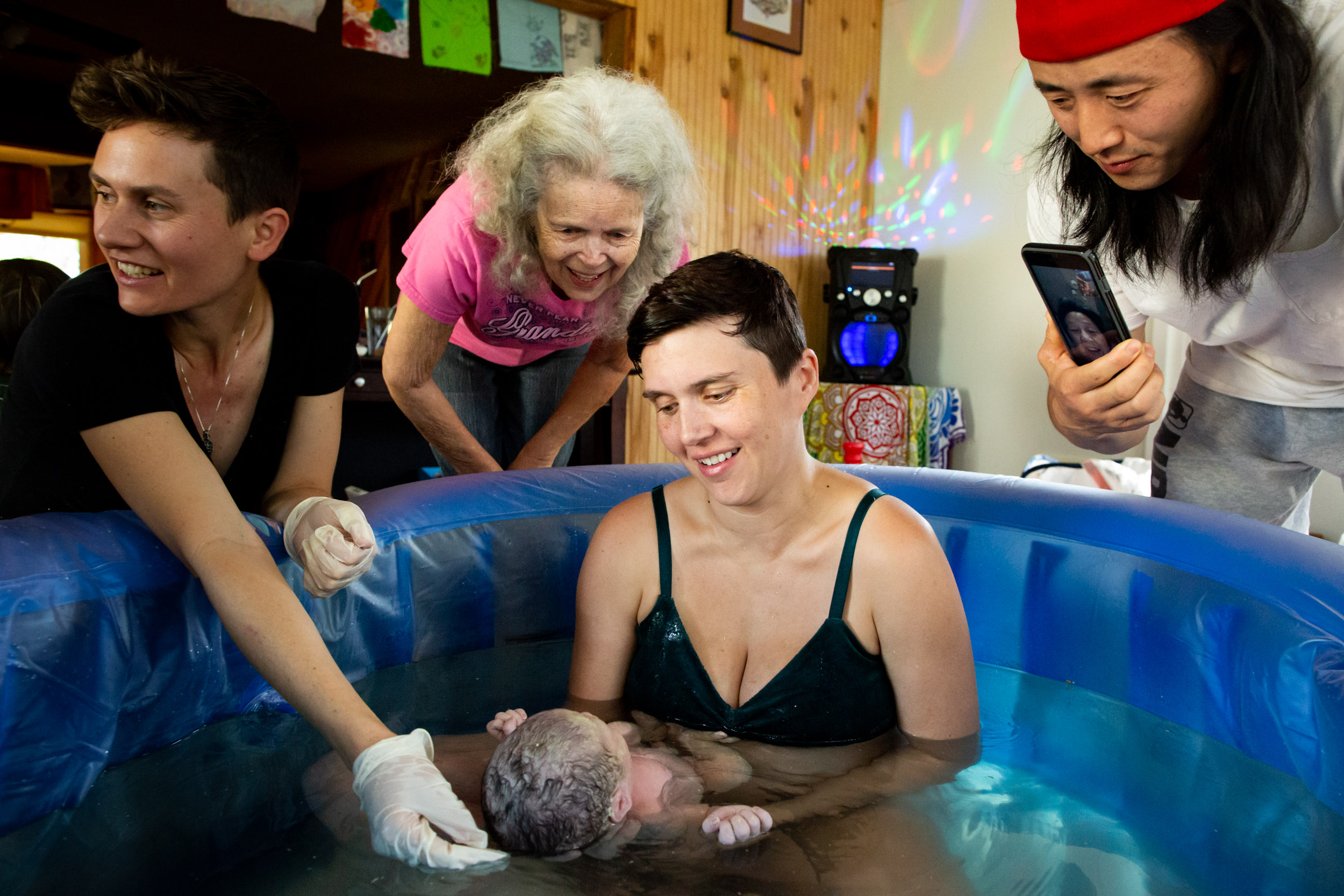 grandparents and parents looking at newborn baby