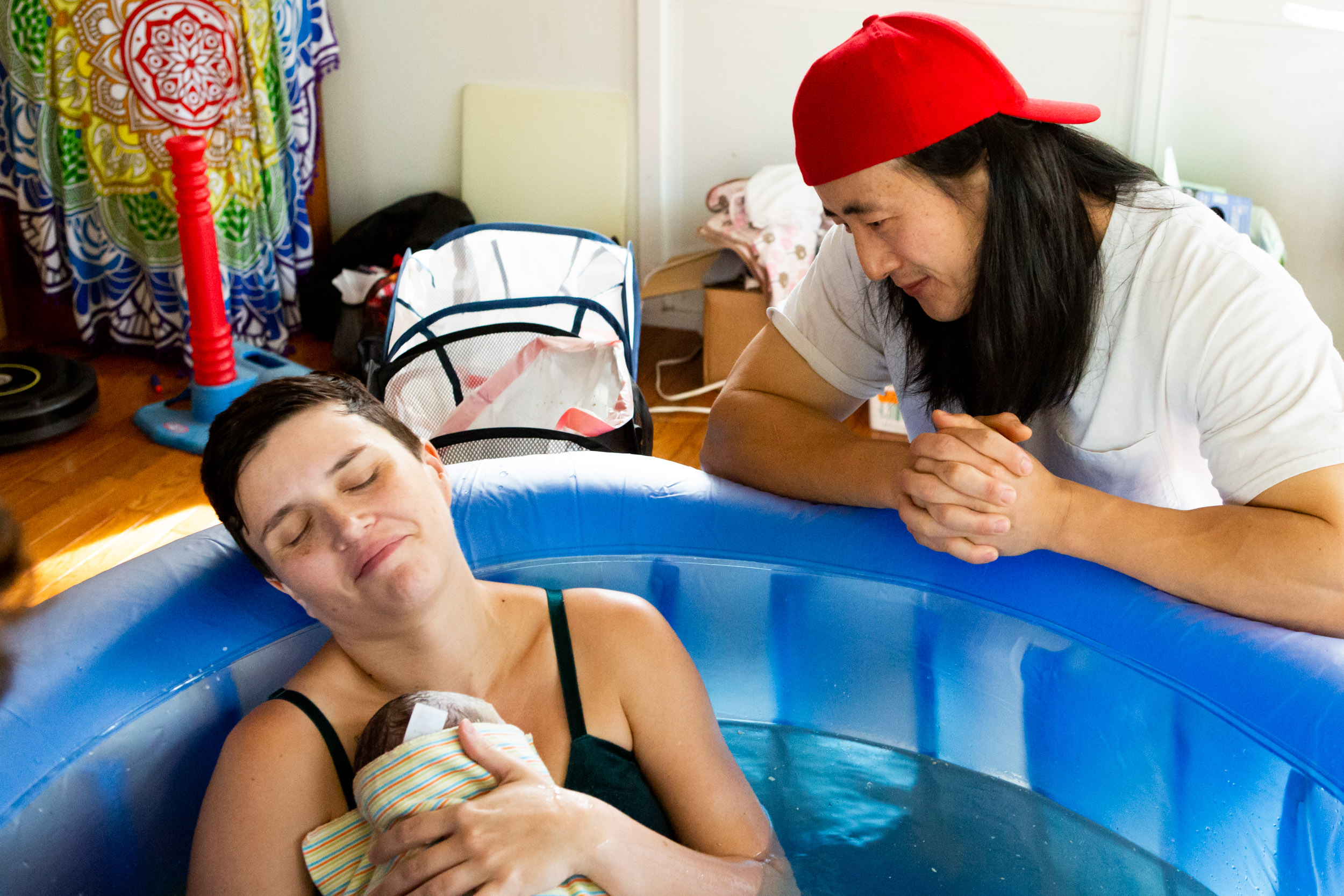 mom holding newborn in tub