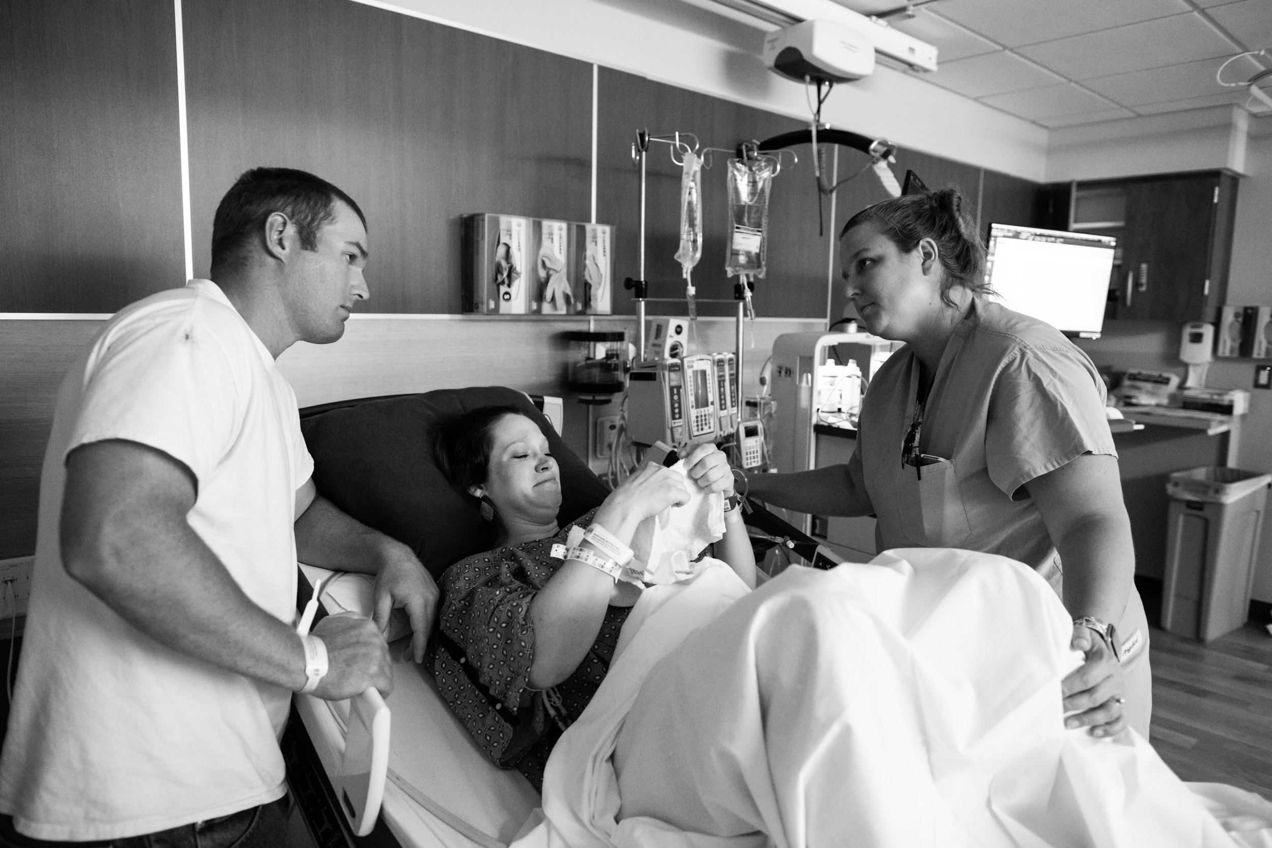 husband and nurse comforting new mom