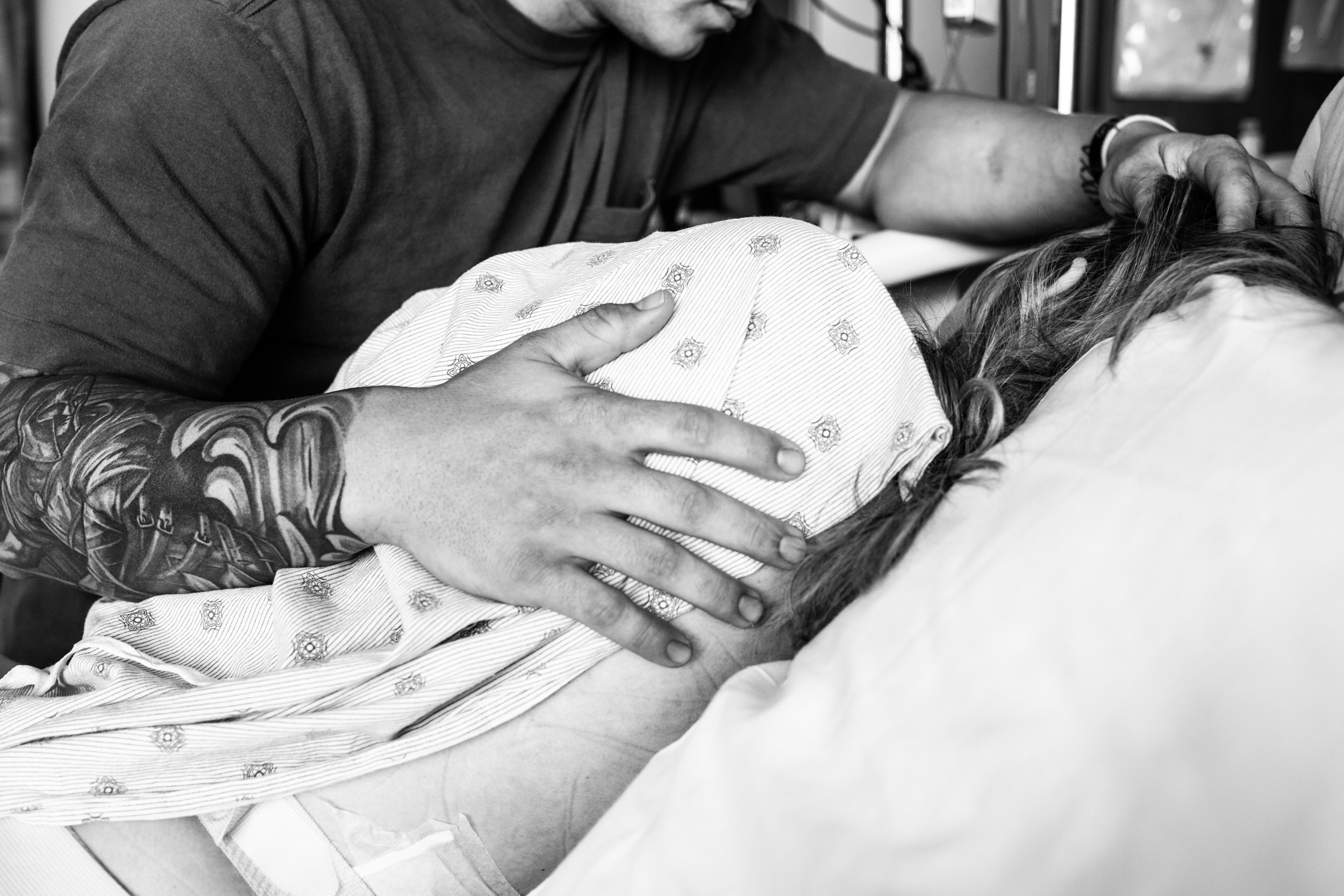 soon-to-be father placing hand on laboring wife's back