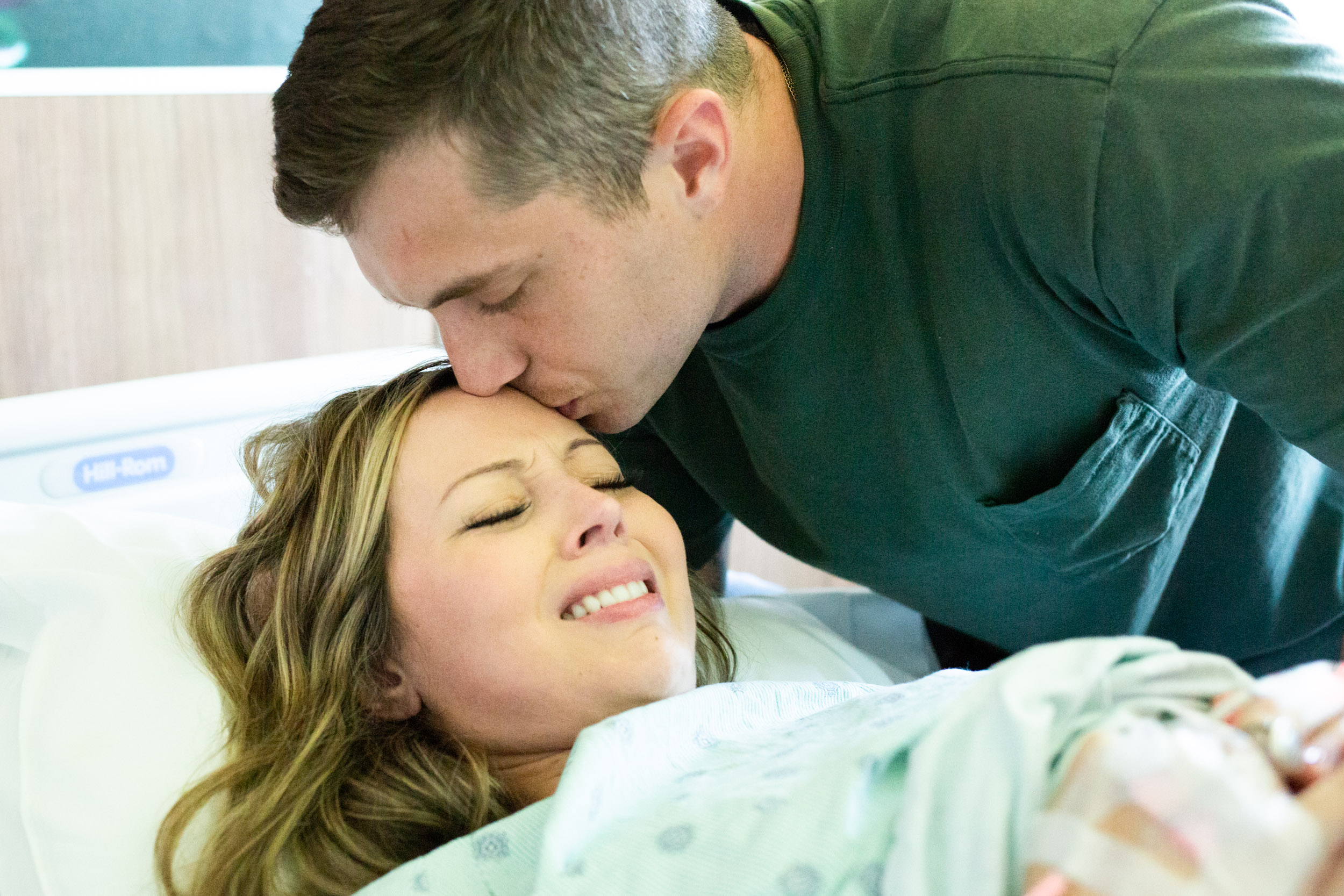 husband kissing wife before baby is born