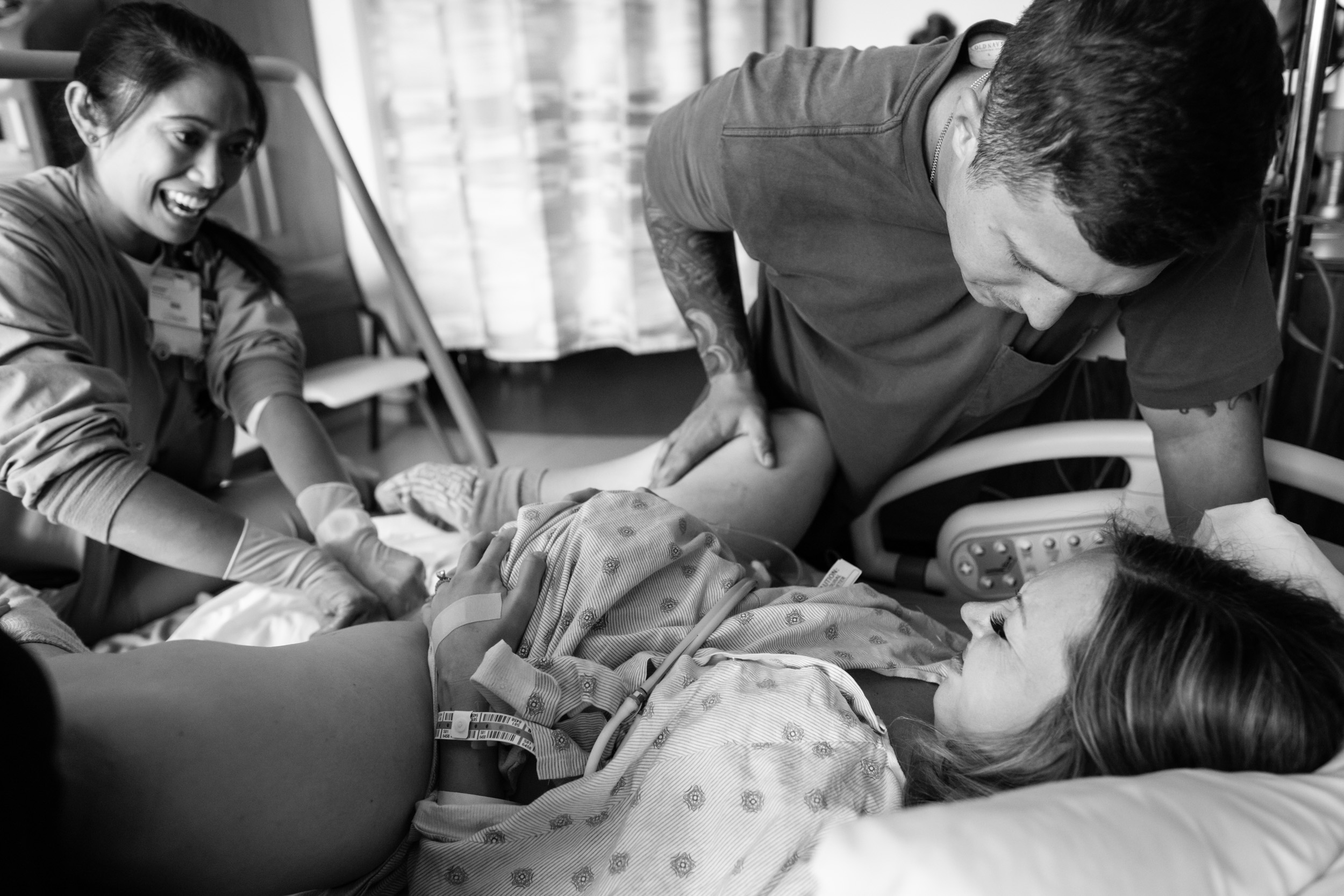 birth mom pushing during labor with her husband and nurse