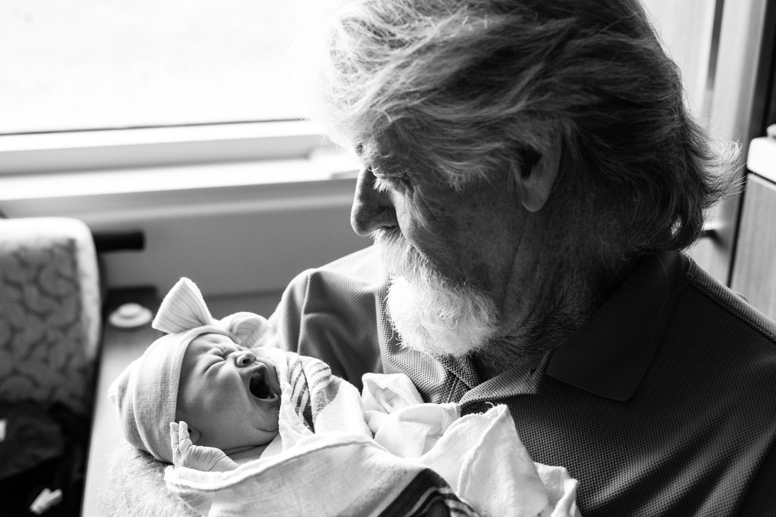 grandfather holding newborn baby girl