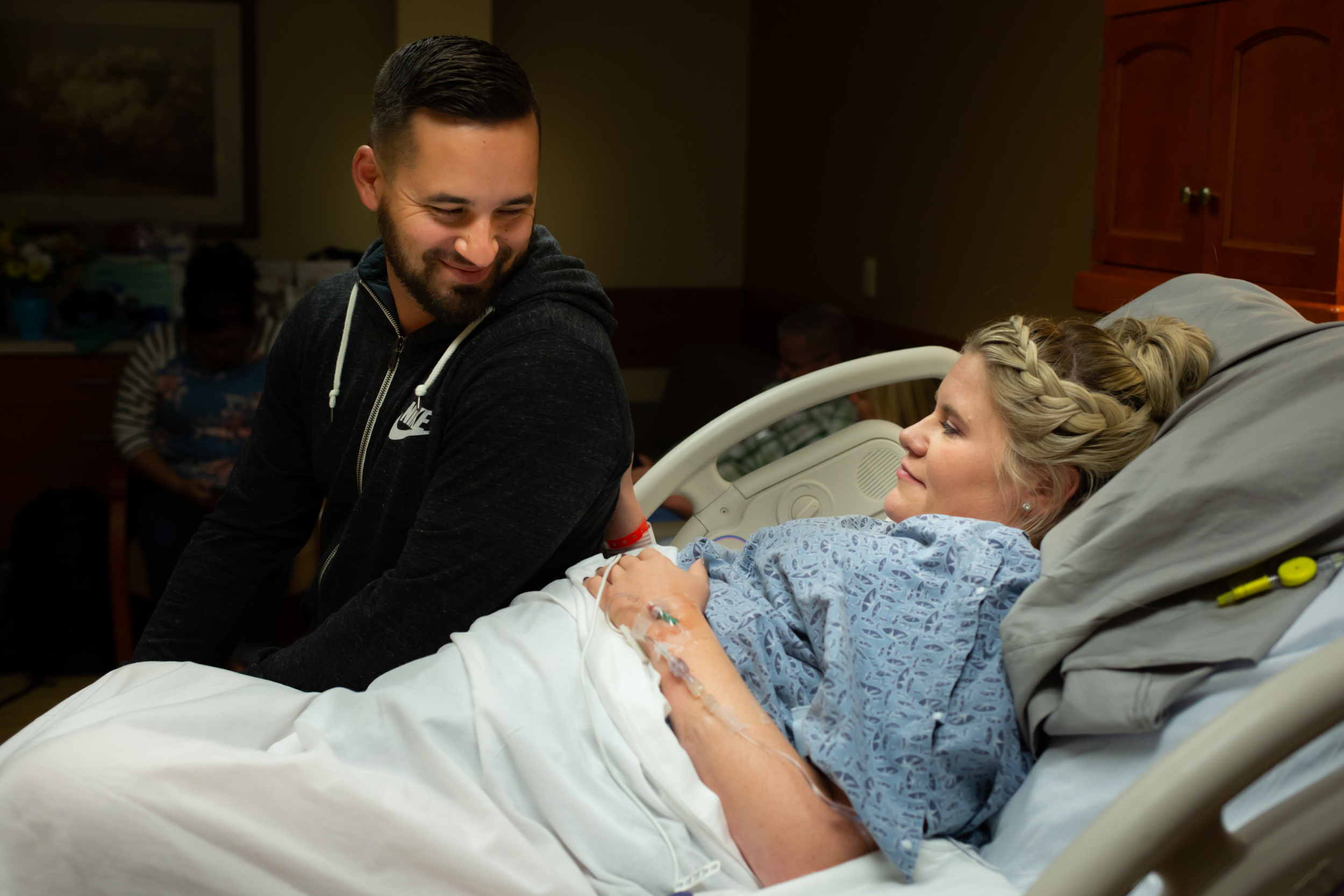 jacksonville husband and wife sitting on hospital bed smiling waiting for birth