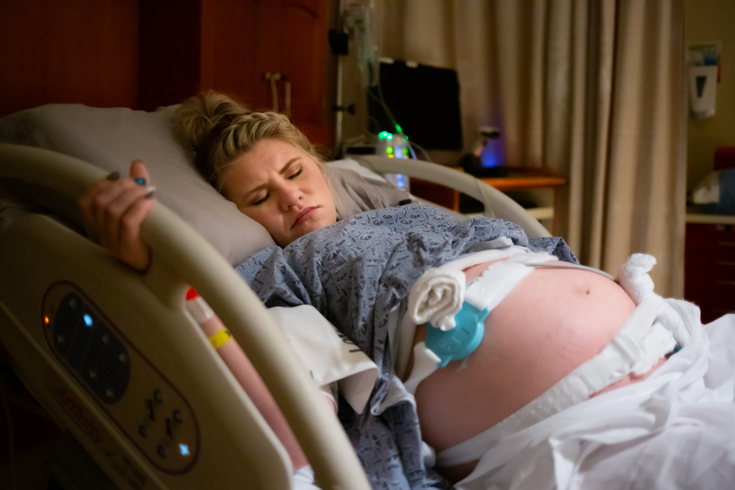 pregnant mom gripping hospital bed while in labor