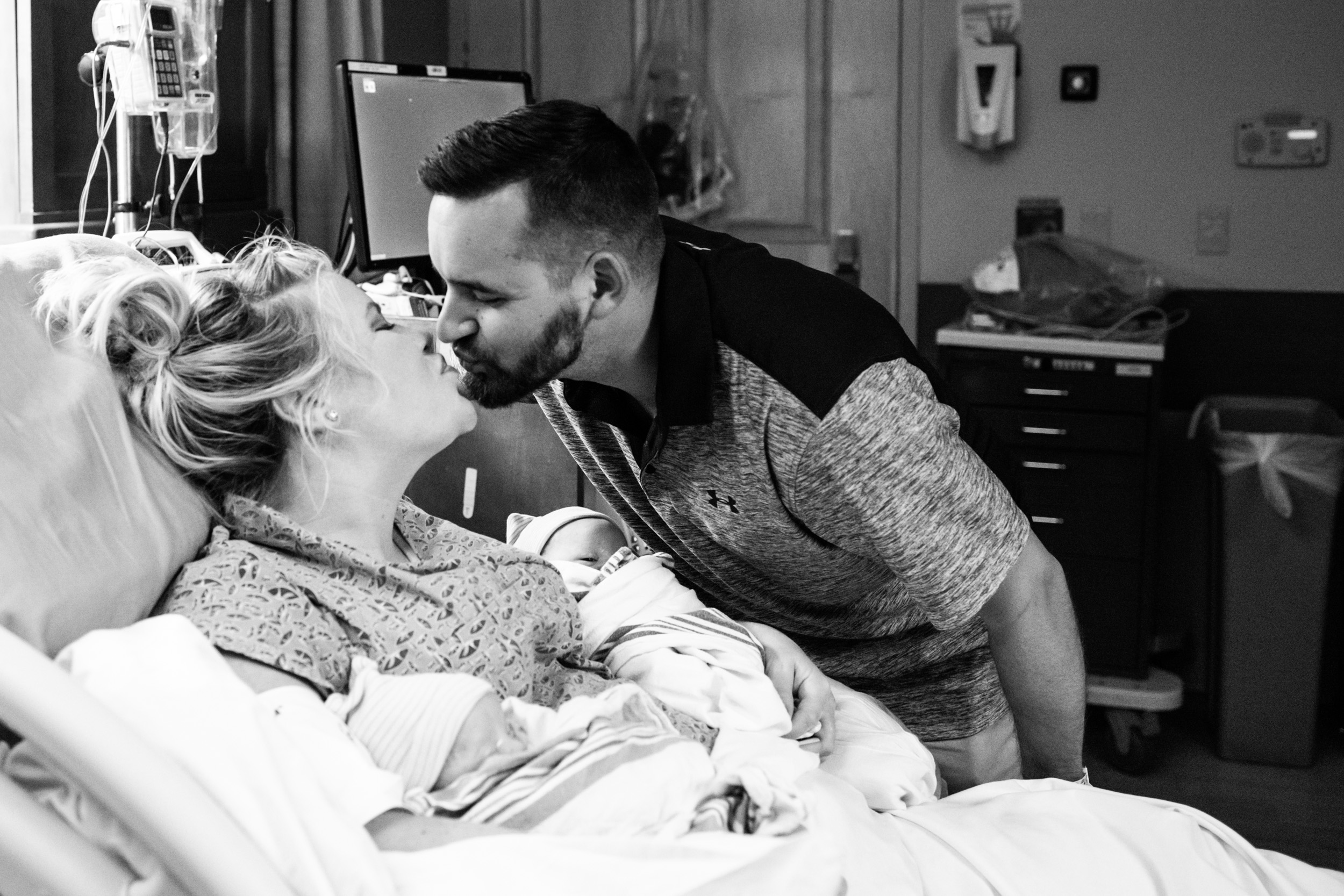 new parents kissing after birth