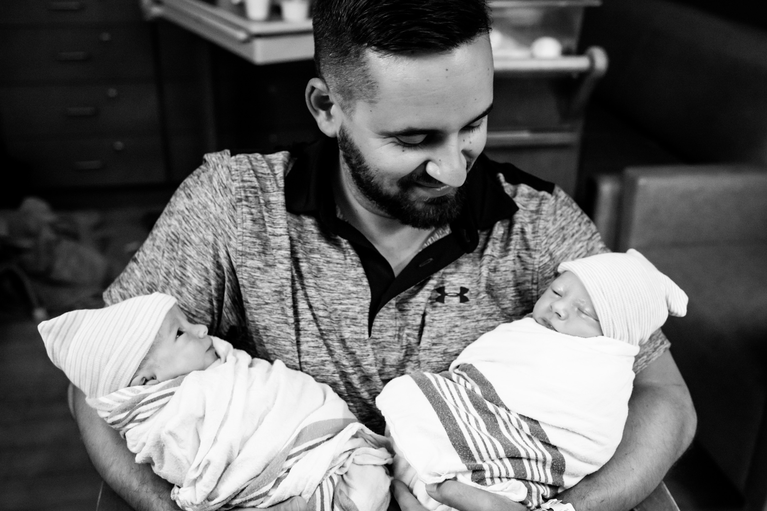 dad holding both twin boys and smiling