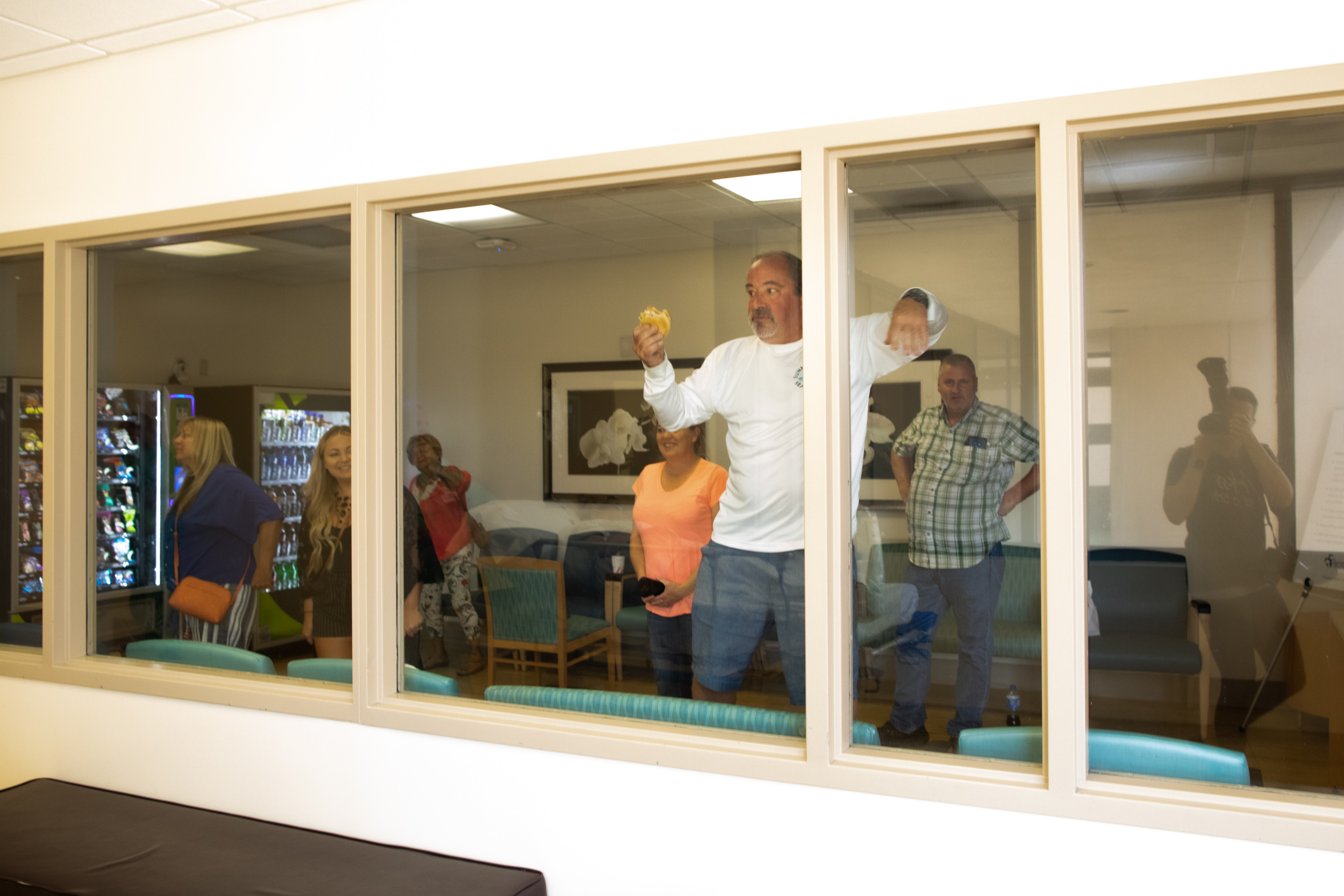 family cheering as newborn babies are rolled by the hospital waiting room