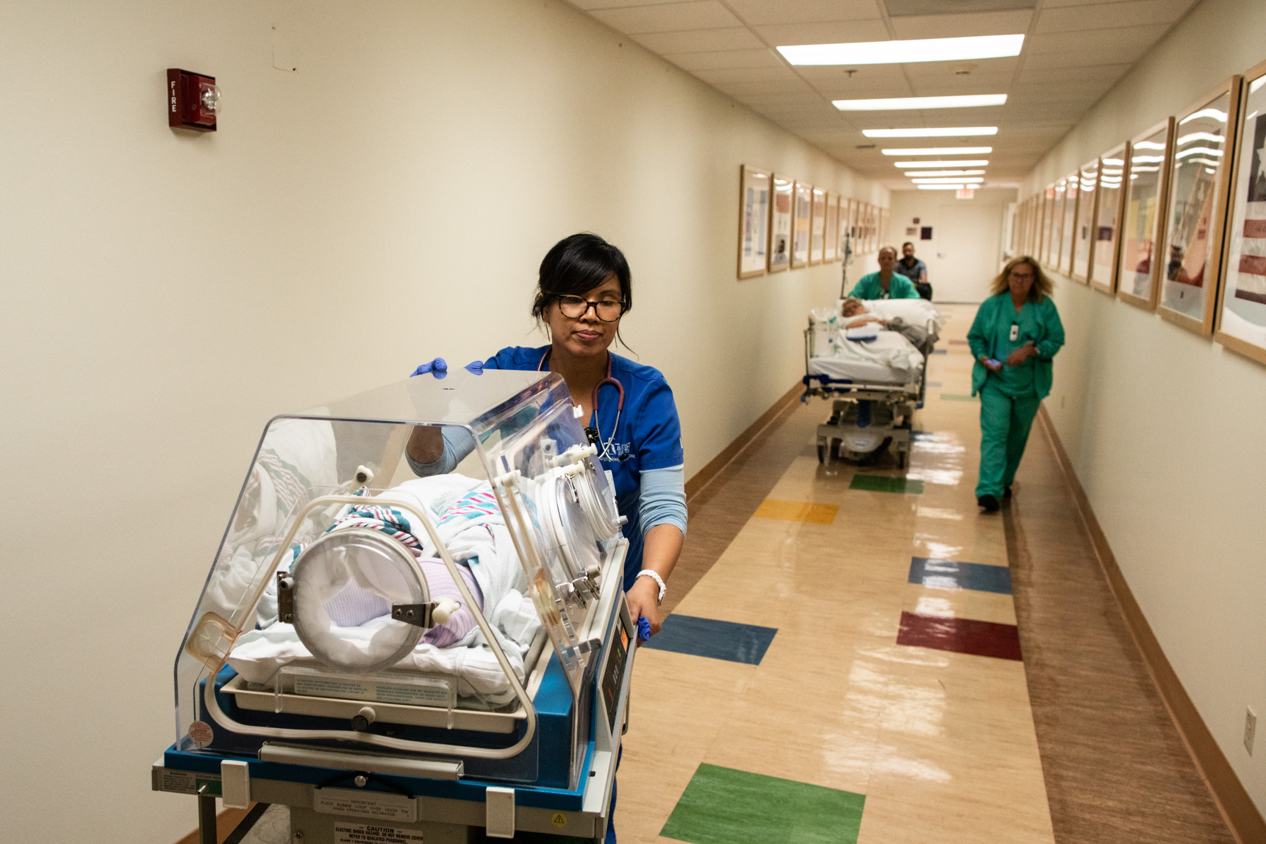 nurses transporting mom and babies to postpartum unit