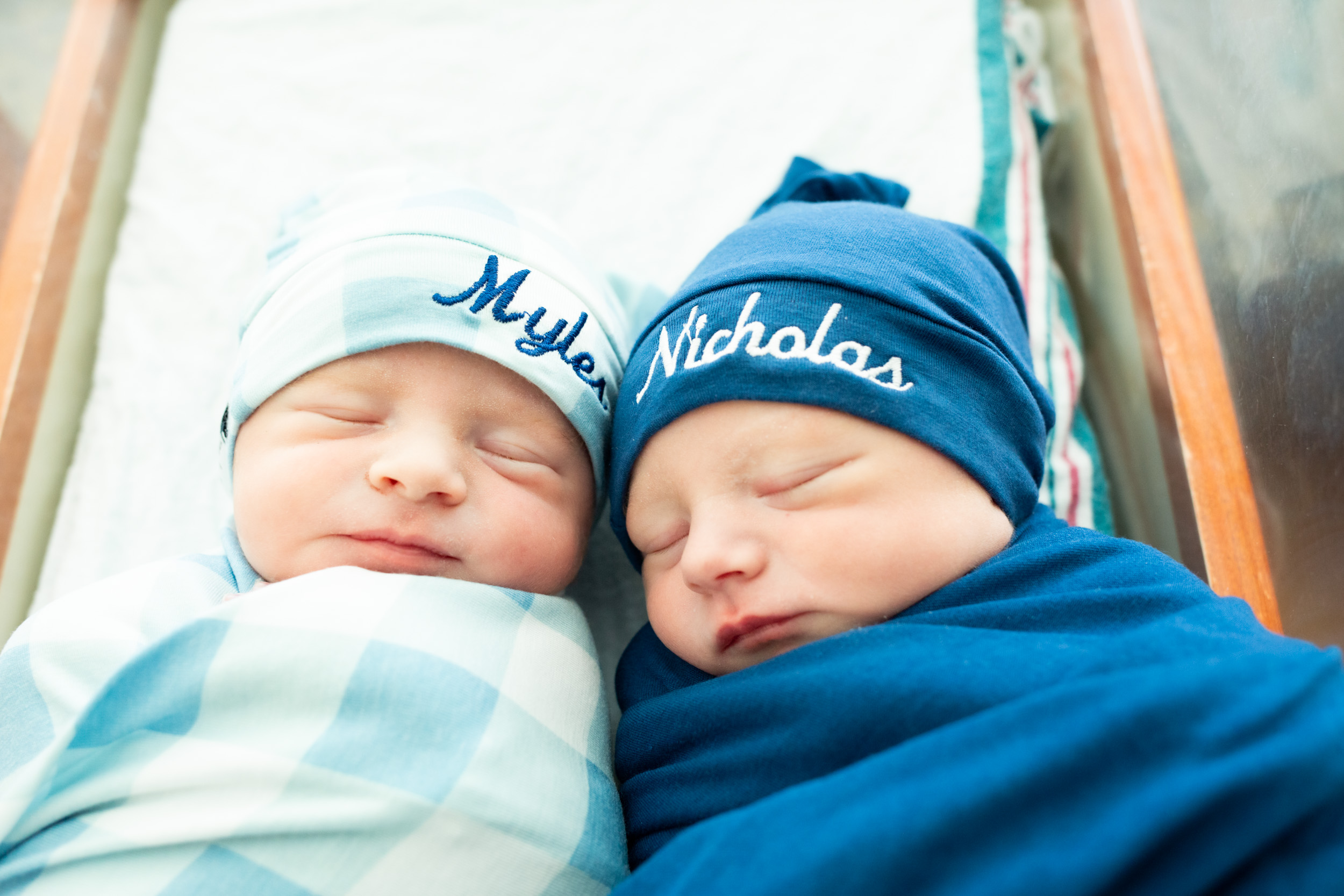 newborn twin babies snuggled up together