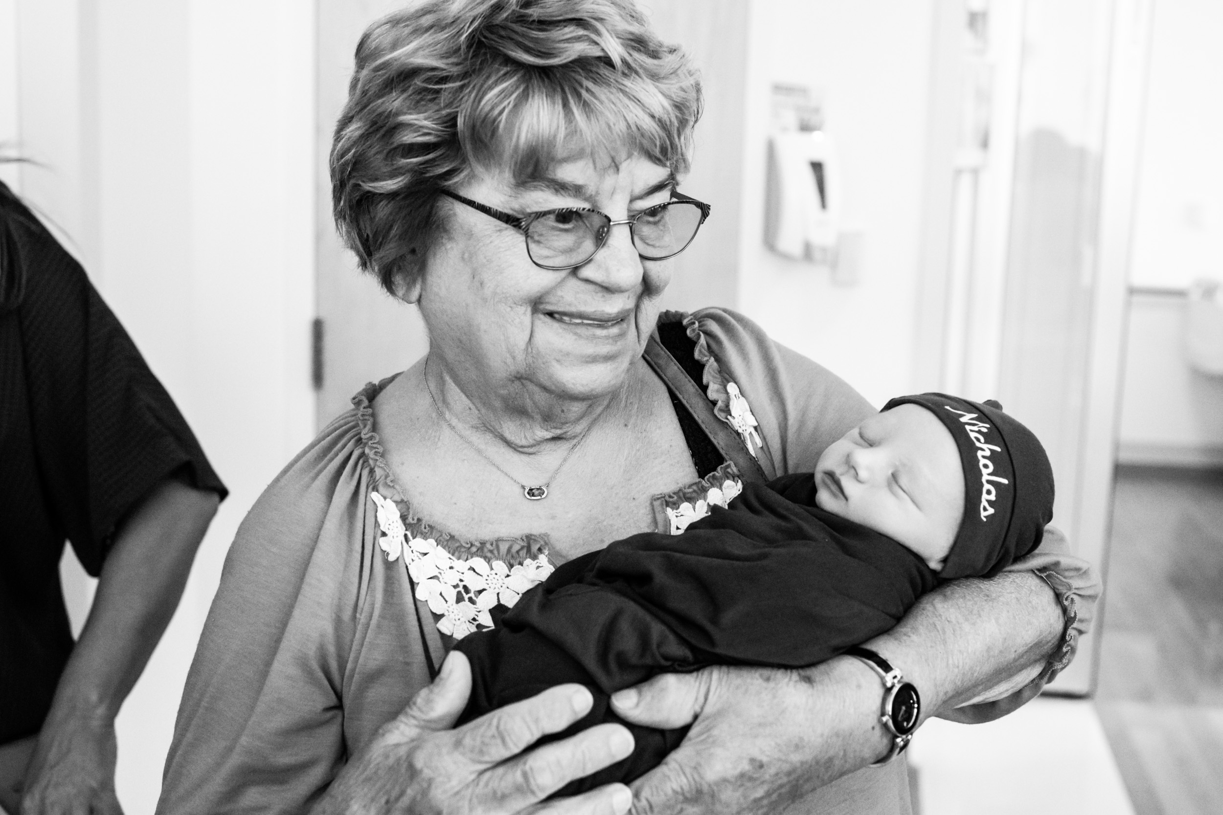 great grandmother holding great grandson and smiling
