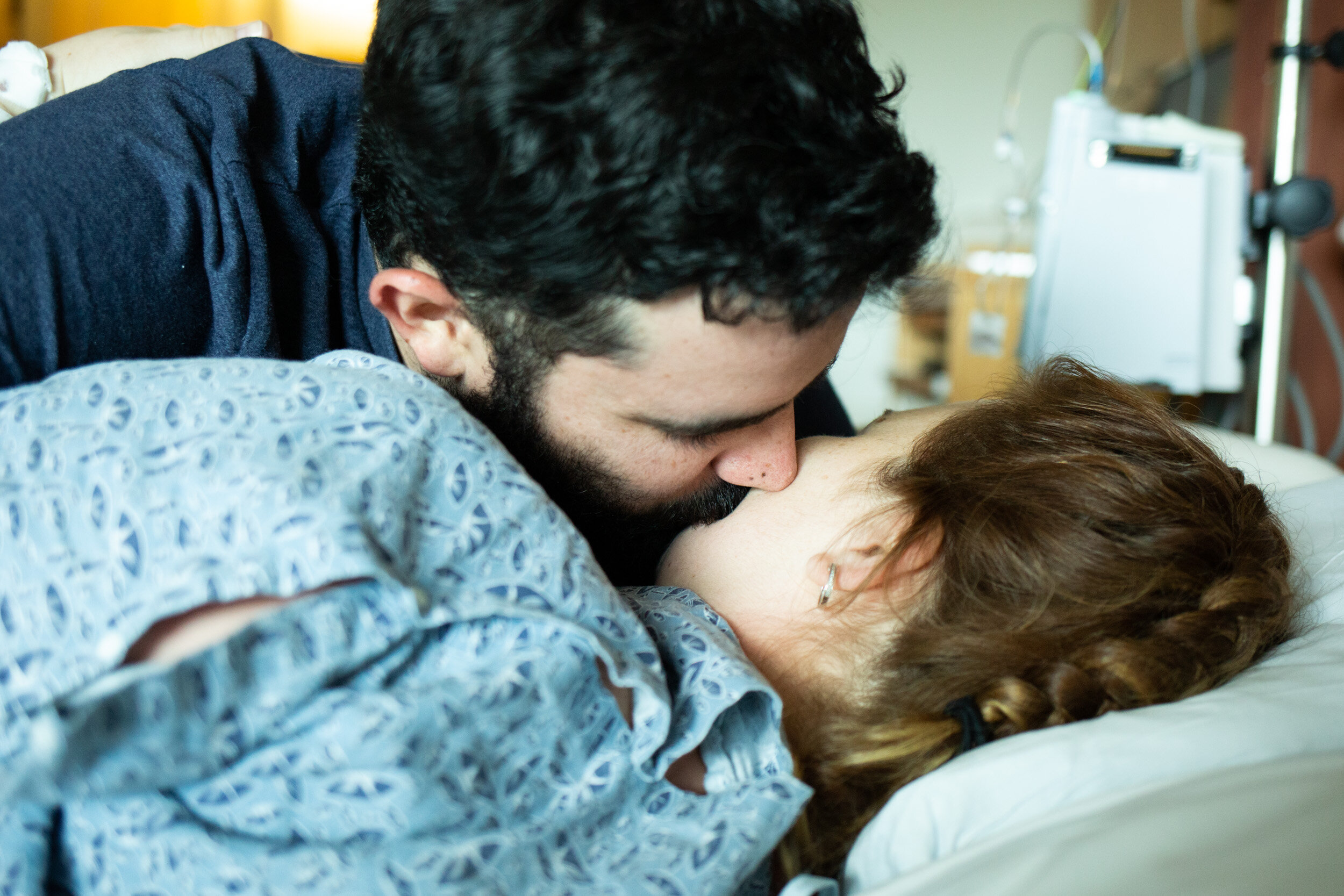 husband kissing wife before birth of their baby