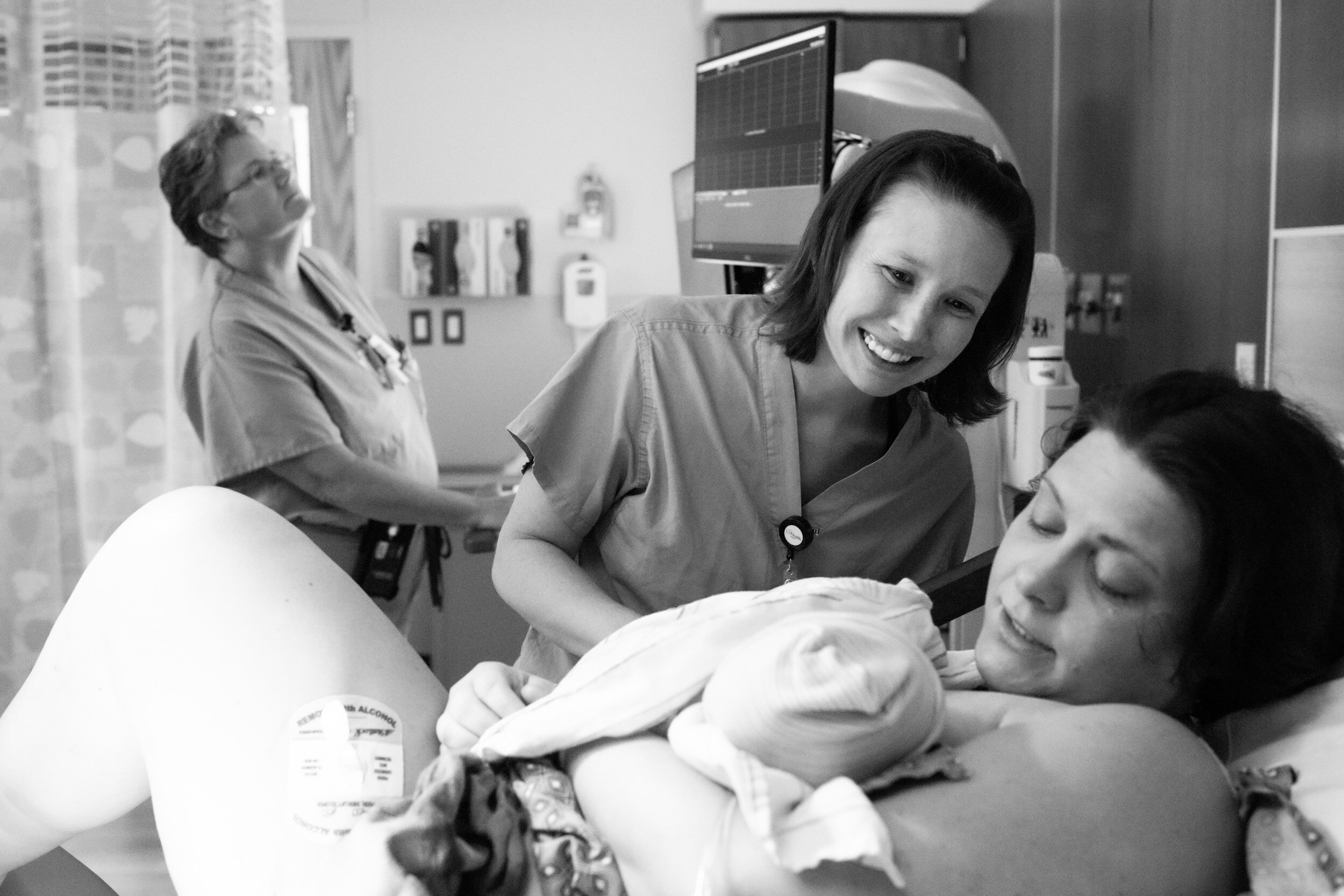 nurse admiring newborn baby girl