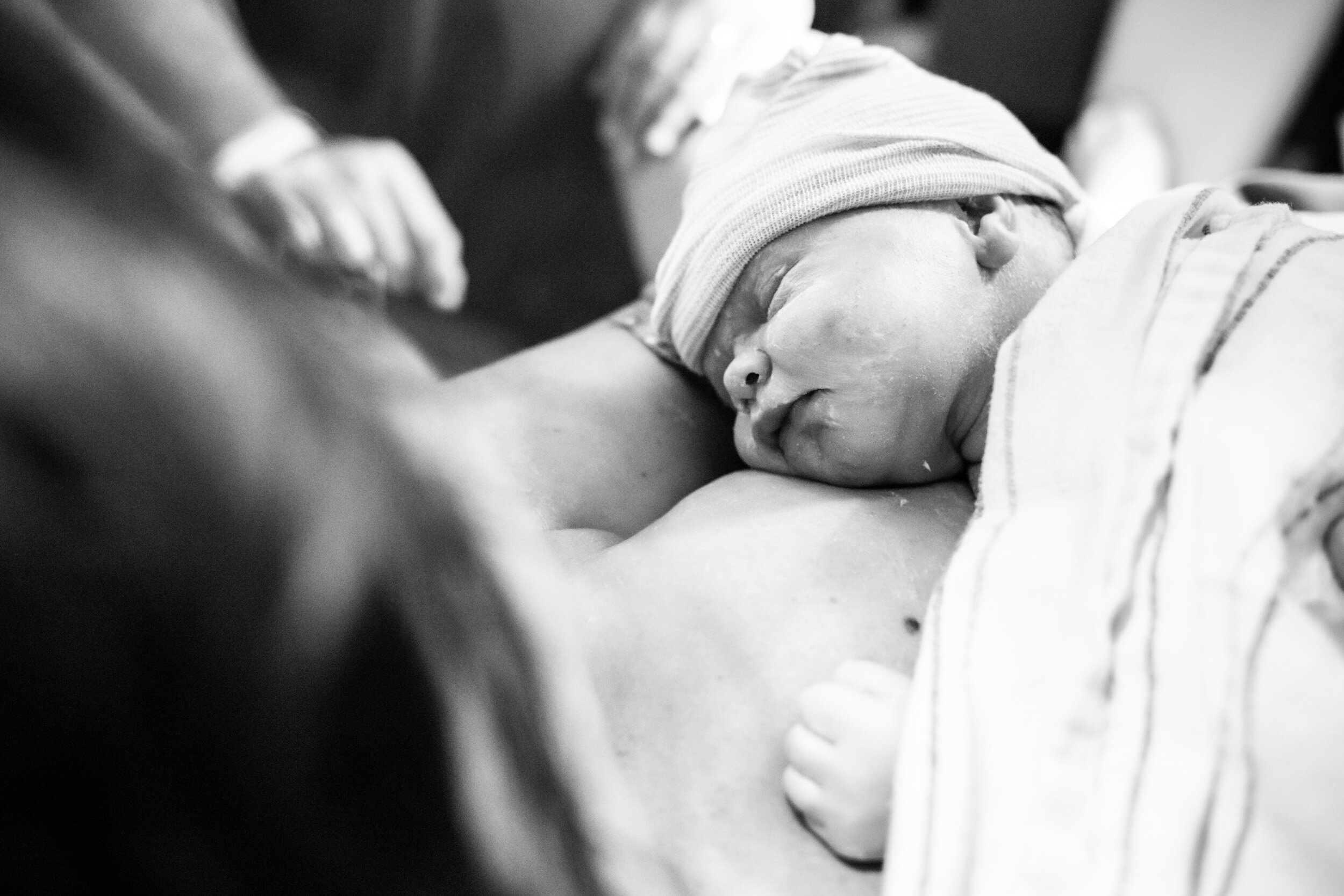 newborn baby girl resting on mom's chest