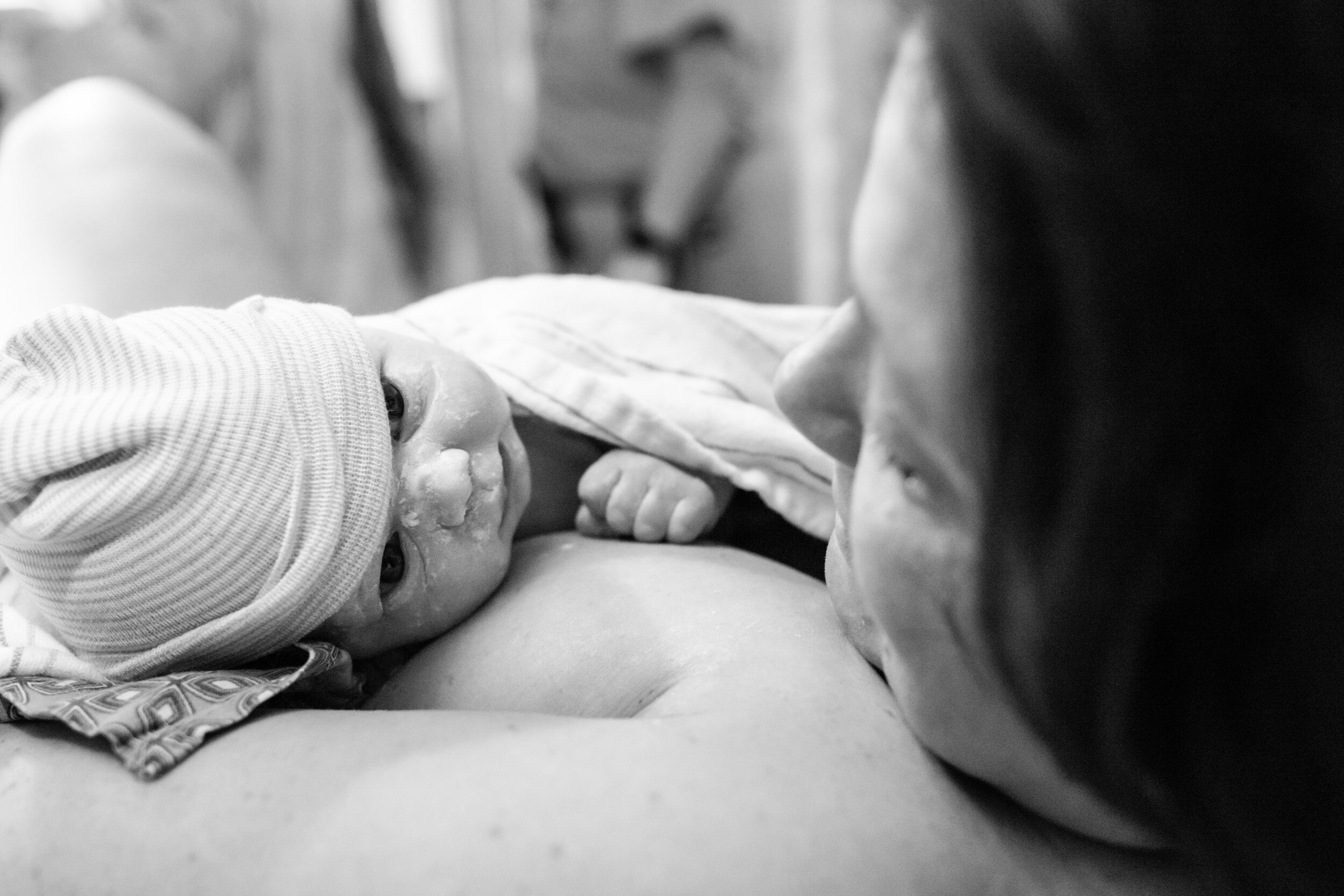 baby girl looking at her mom just after birth