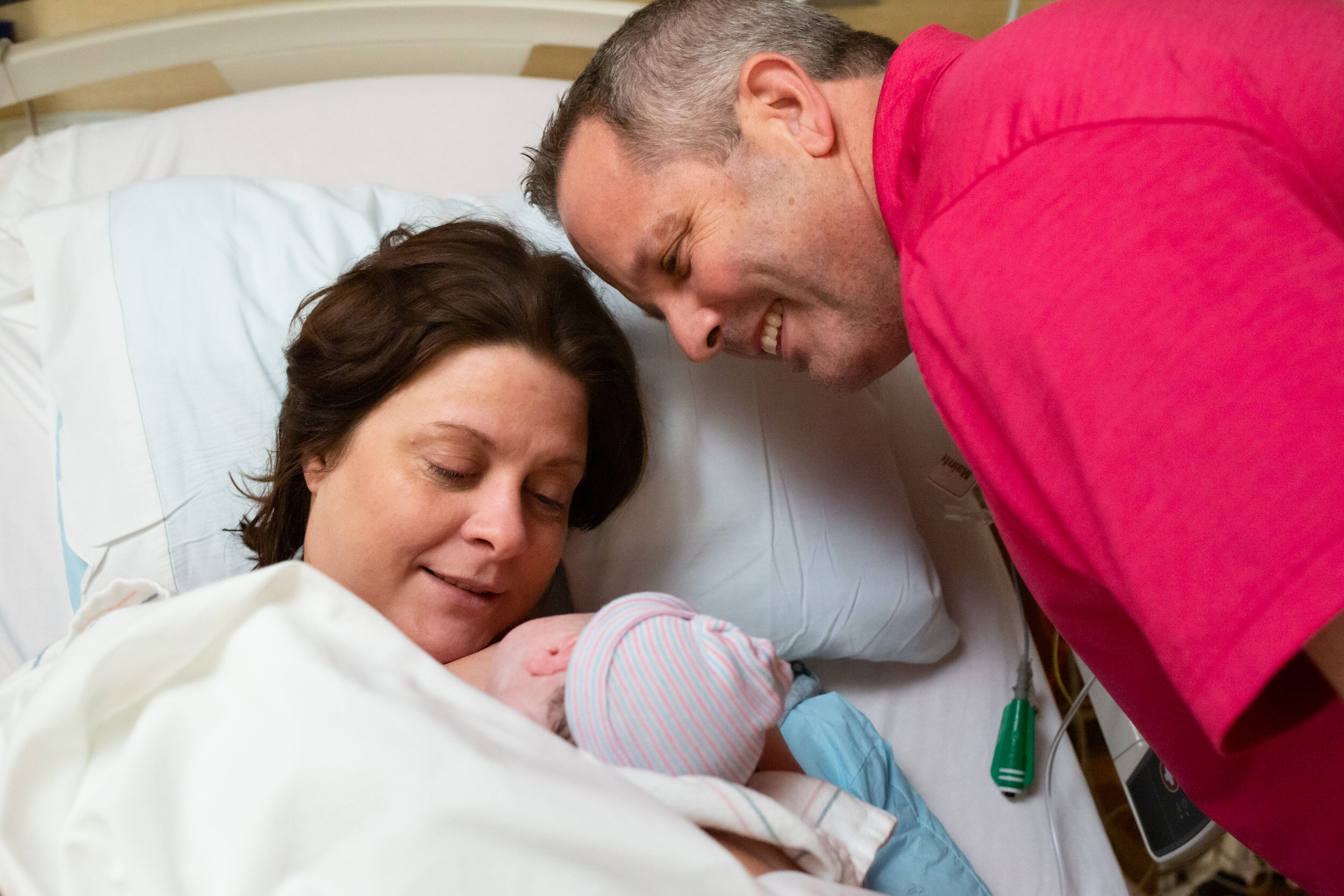 husband and wife looking at their newborn baby girl