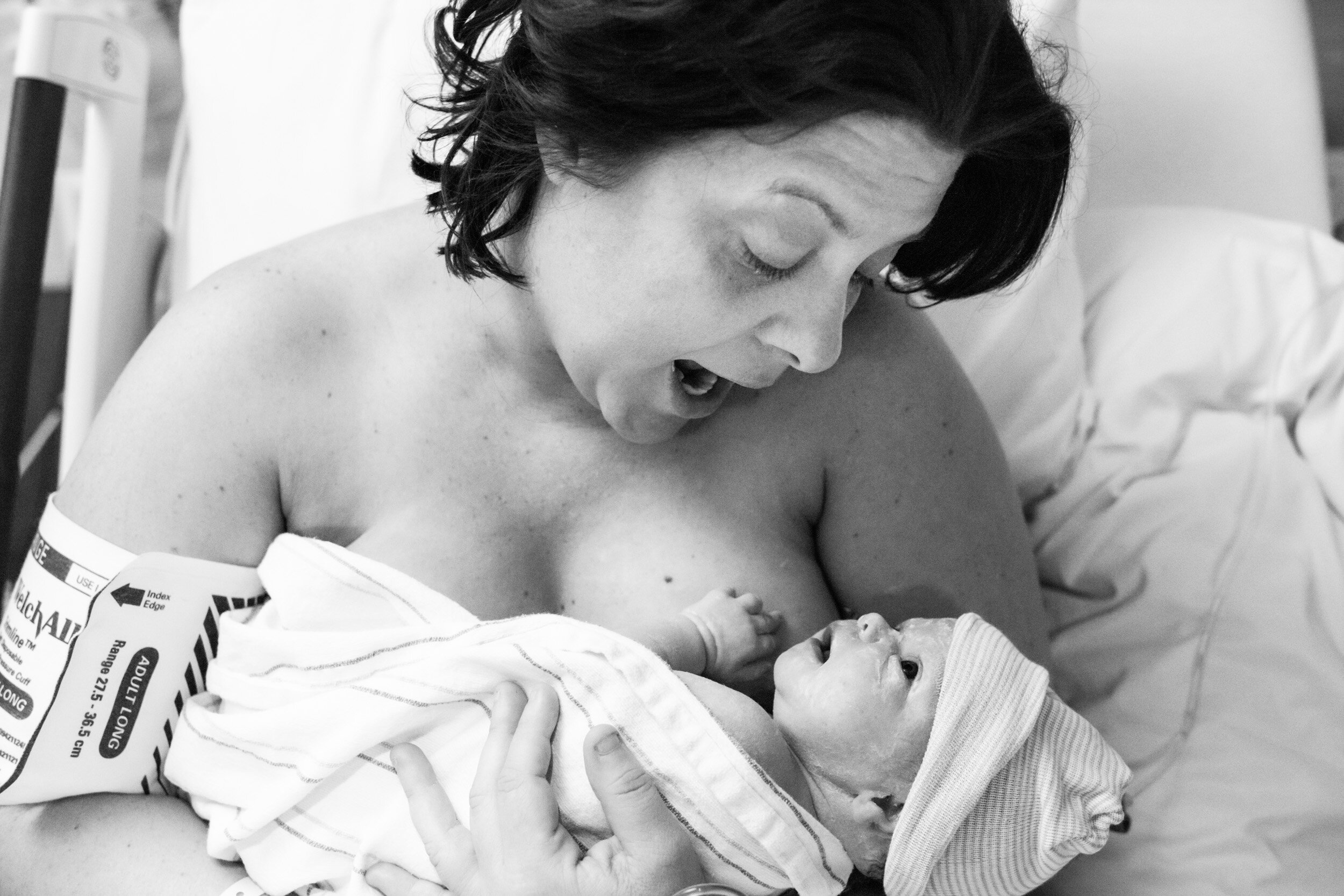 mom smiling at her baby girl just after birth