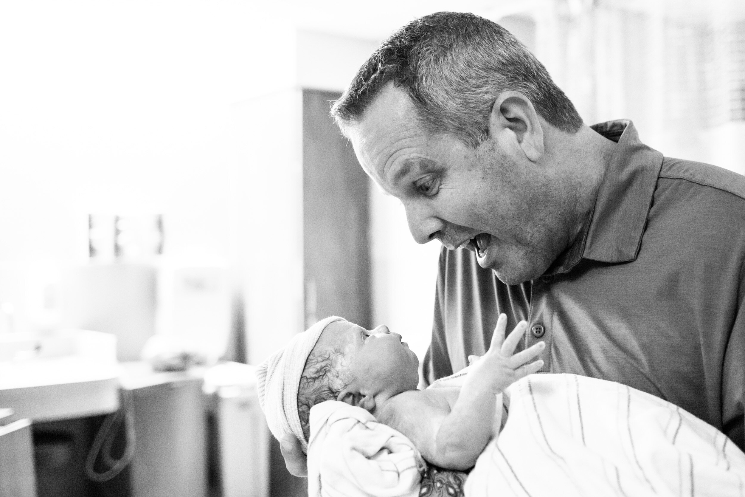gainesville dad smiling at his newborn baby girl