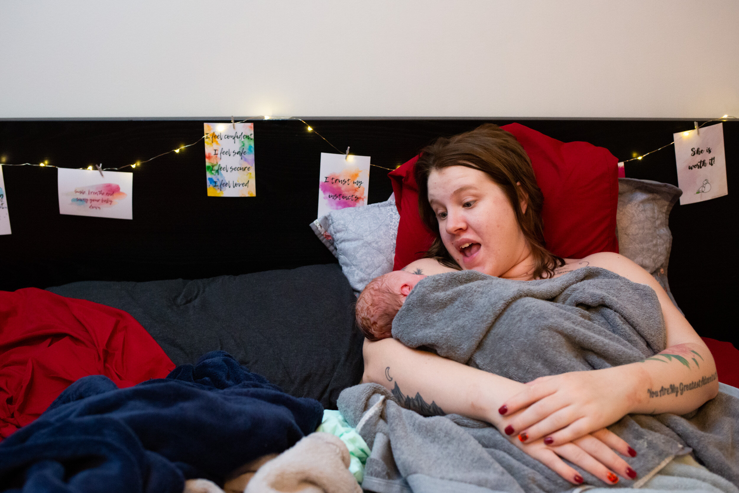 new mom nursing and smiling at their baby girl