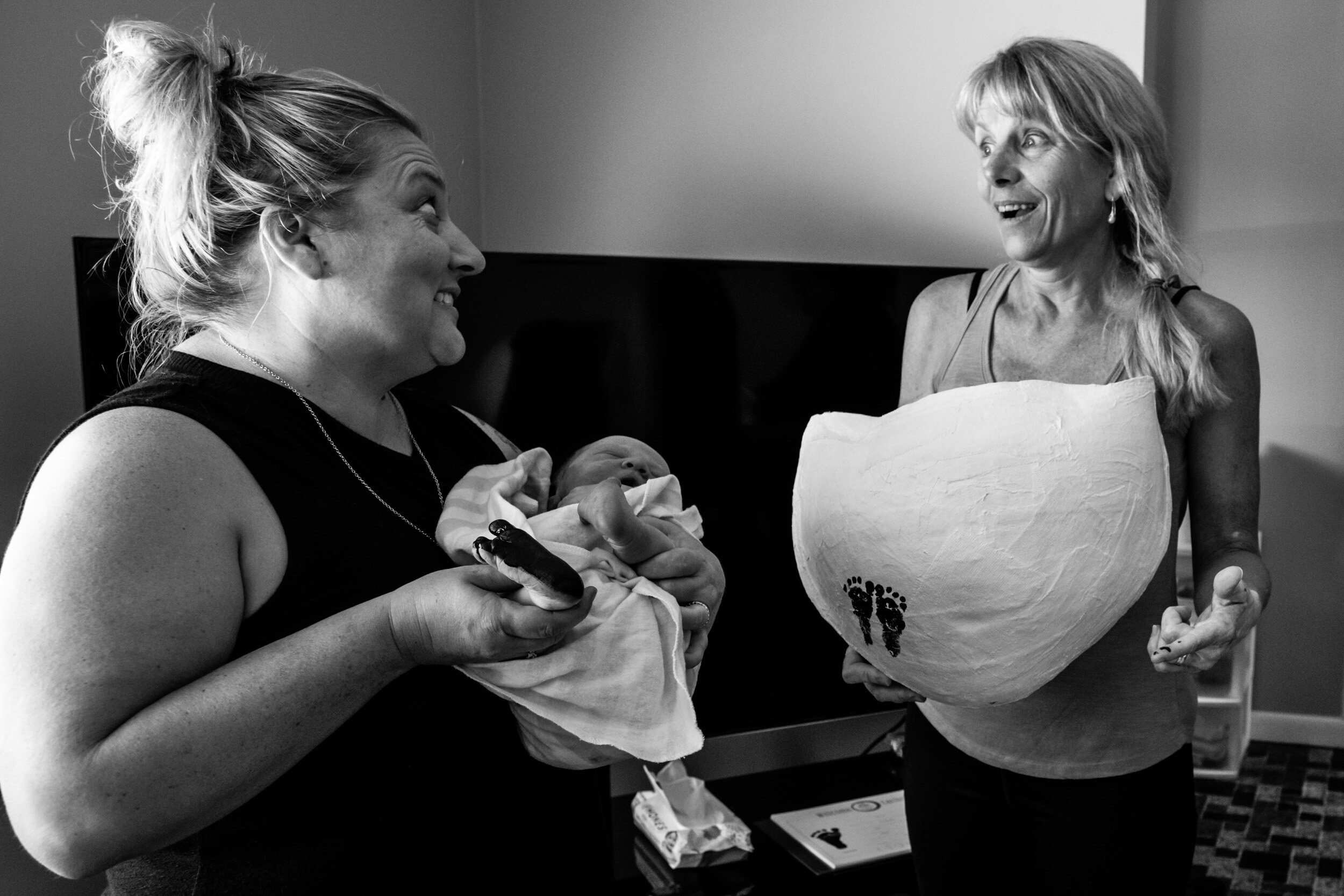 midwife and doula laughing after making baby's footprints