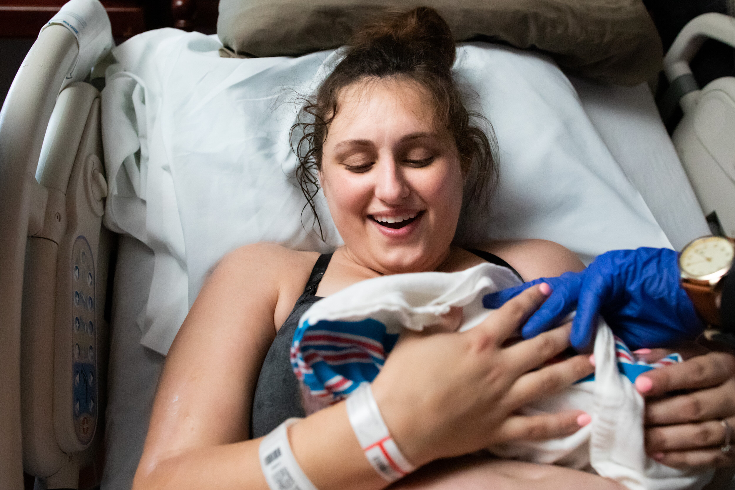 mom smiling at her newborn baby just after birth