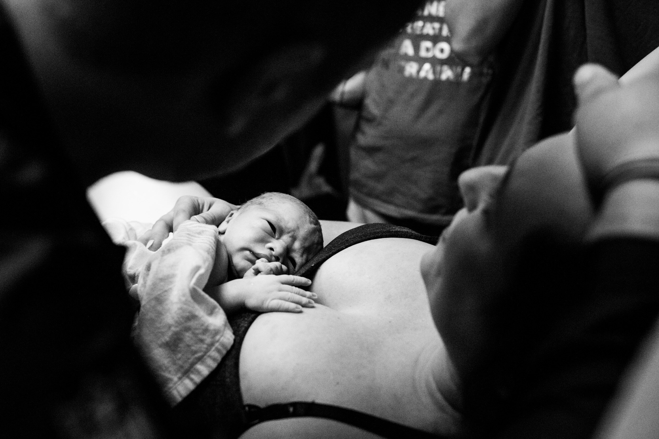 newborn baby resting on his mother's chest