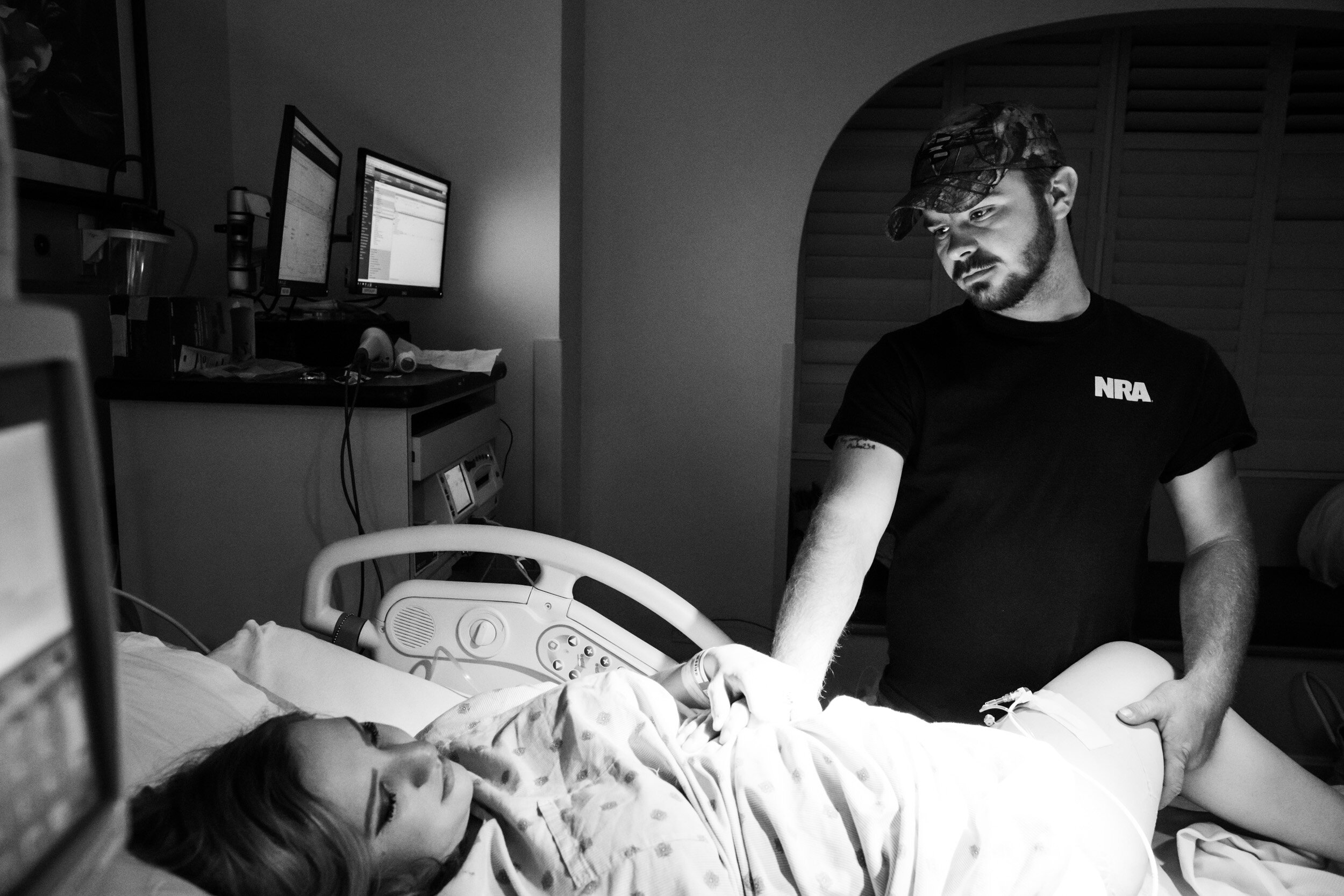 husband holding onto wife while pushing during childbirth