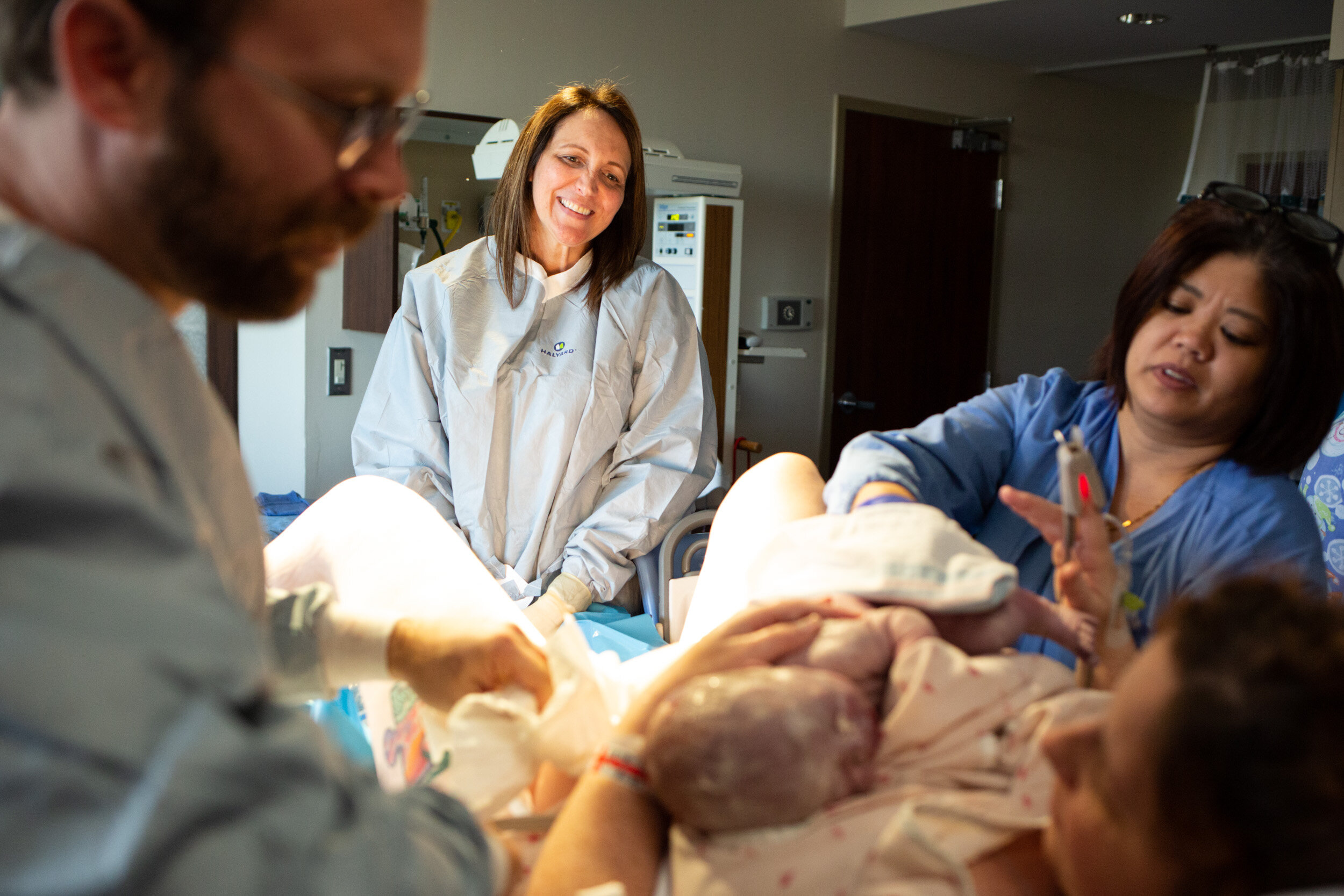 midwife looking sweetly at mom who just birthed her baby