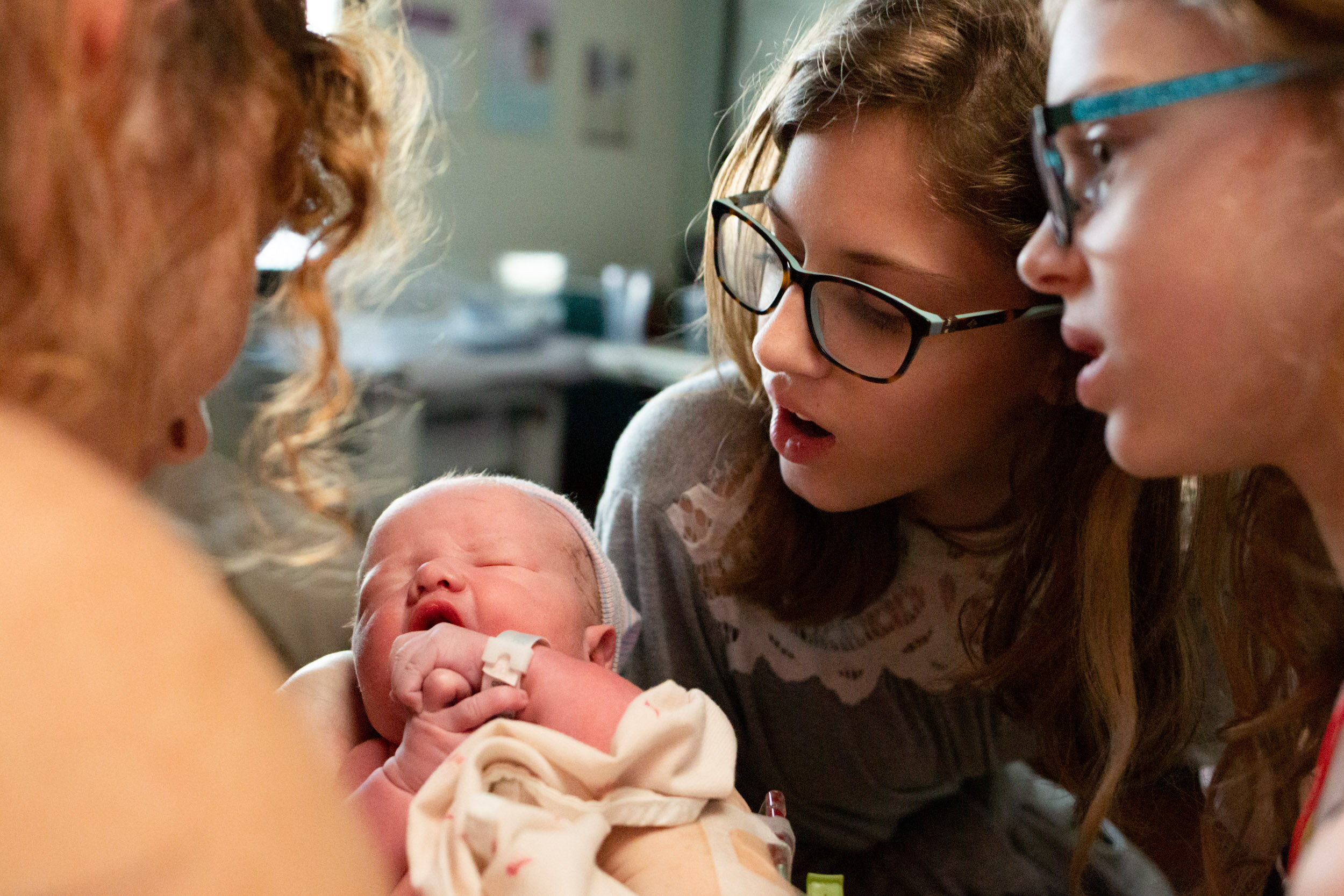 siblings admire baby brother