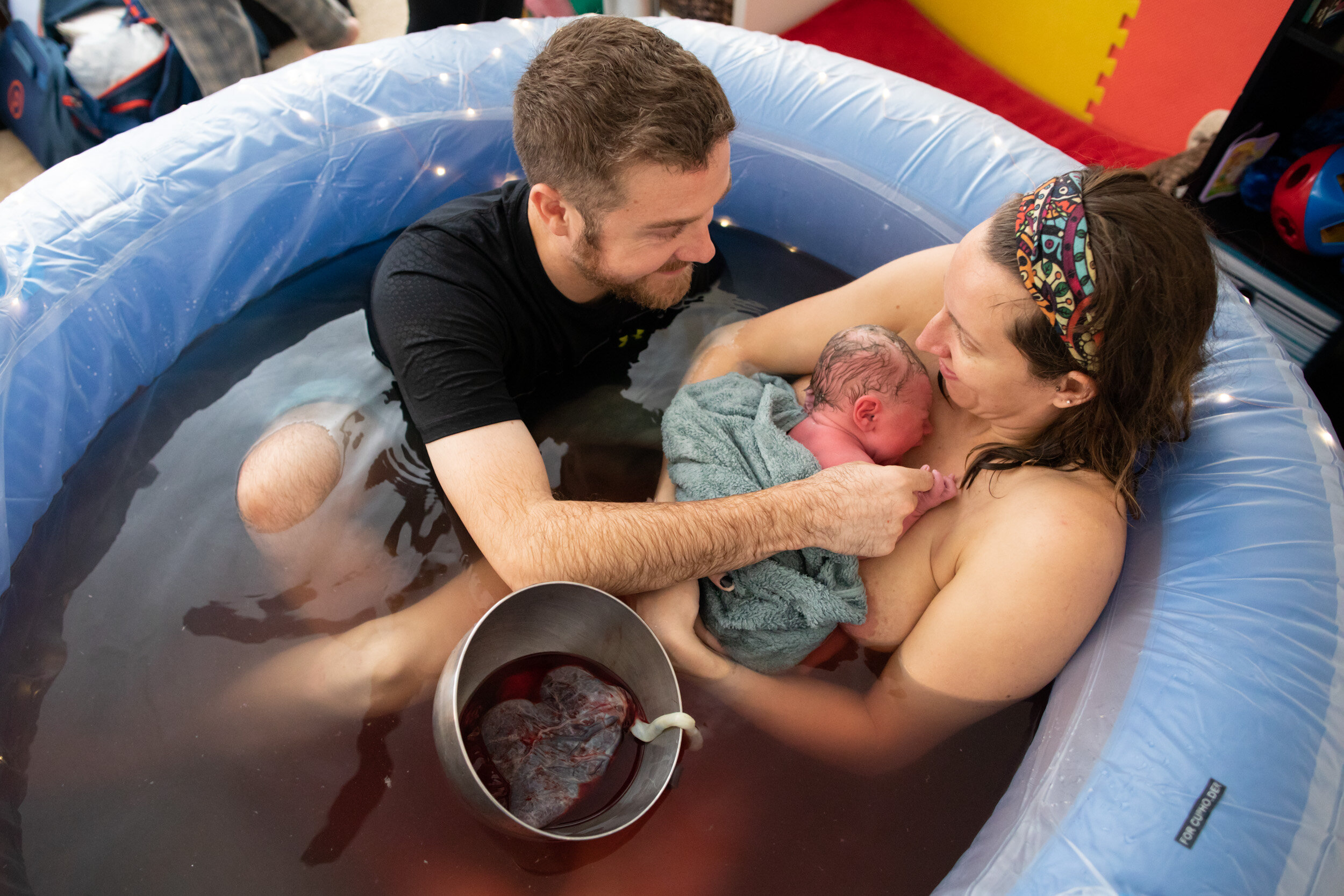 jacksonville parents admiring their newborn baby in birth tub